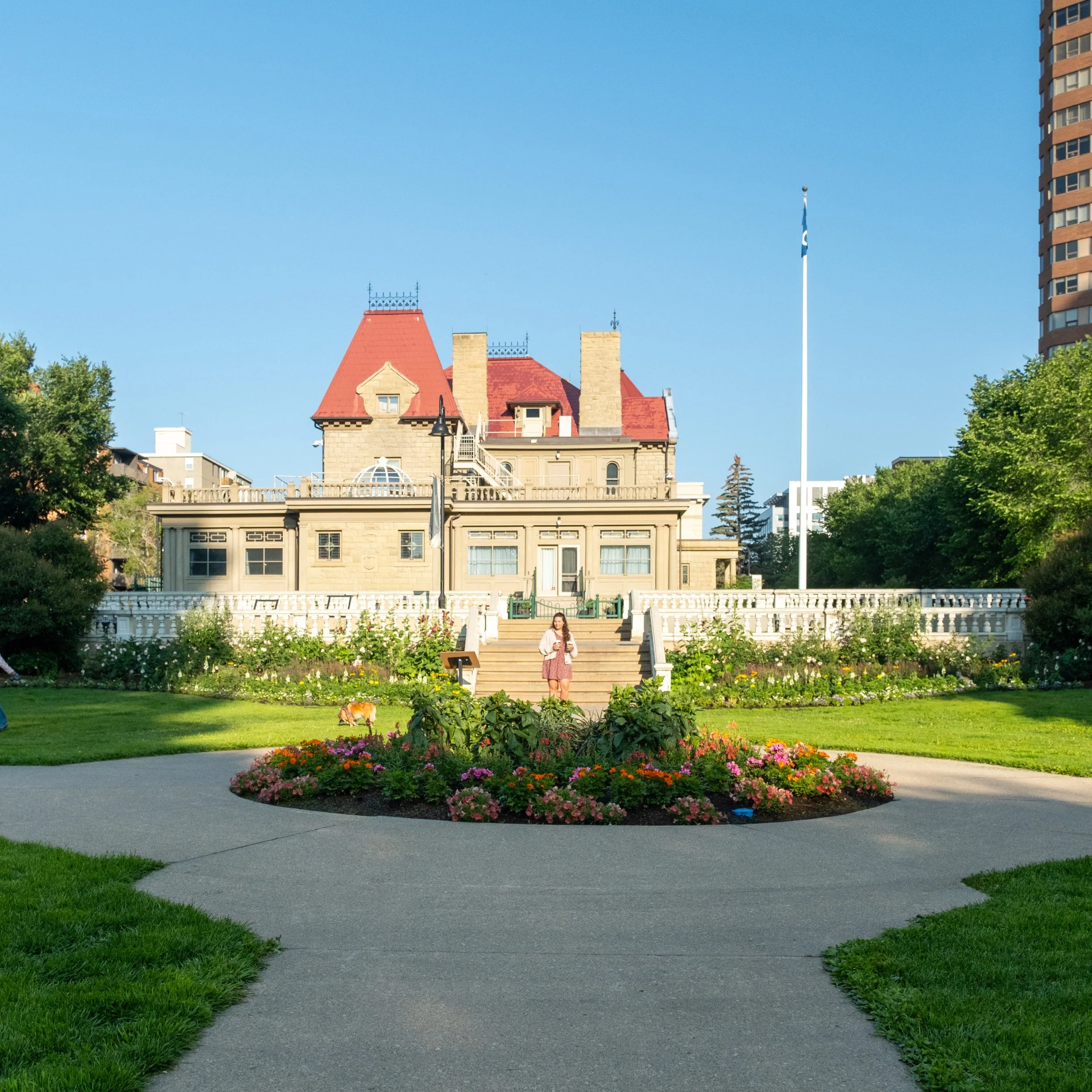 Image of Lougheed House with a large circular flowerbed in the foreground.