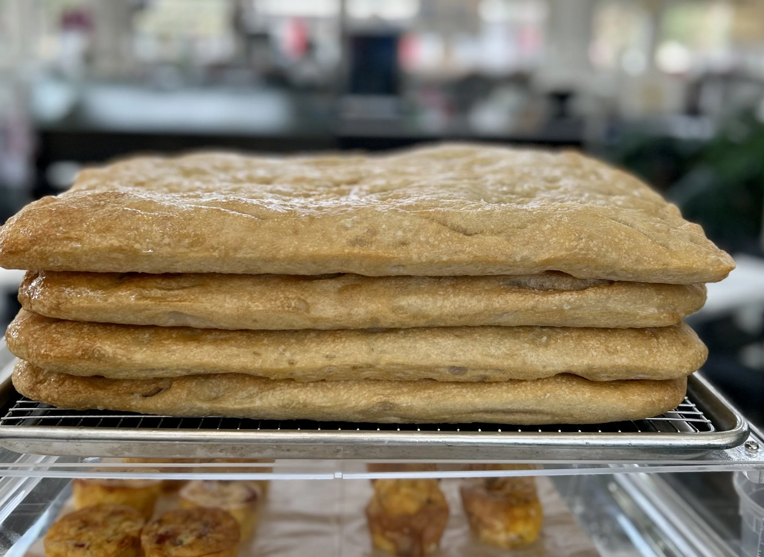 Stack of multiple flatbread or baked goods on a metal cooling rack.