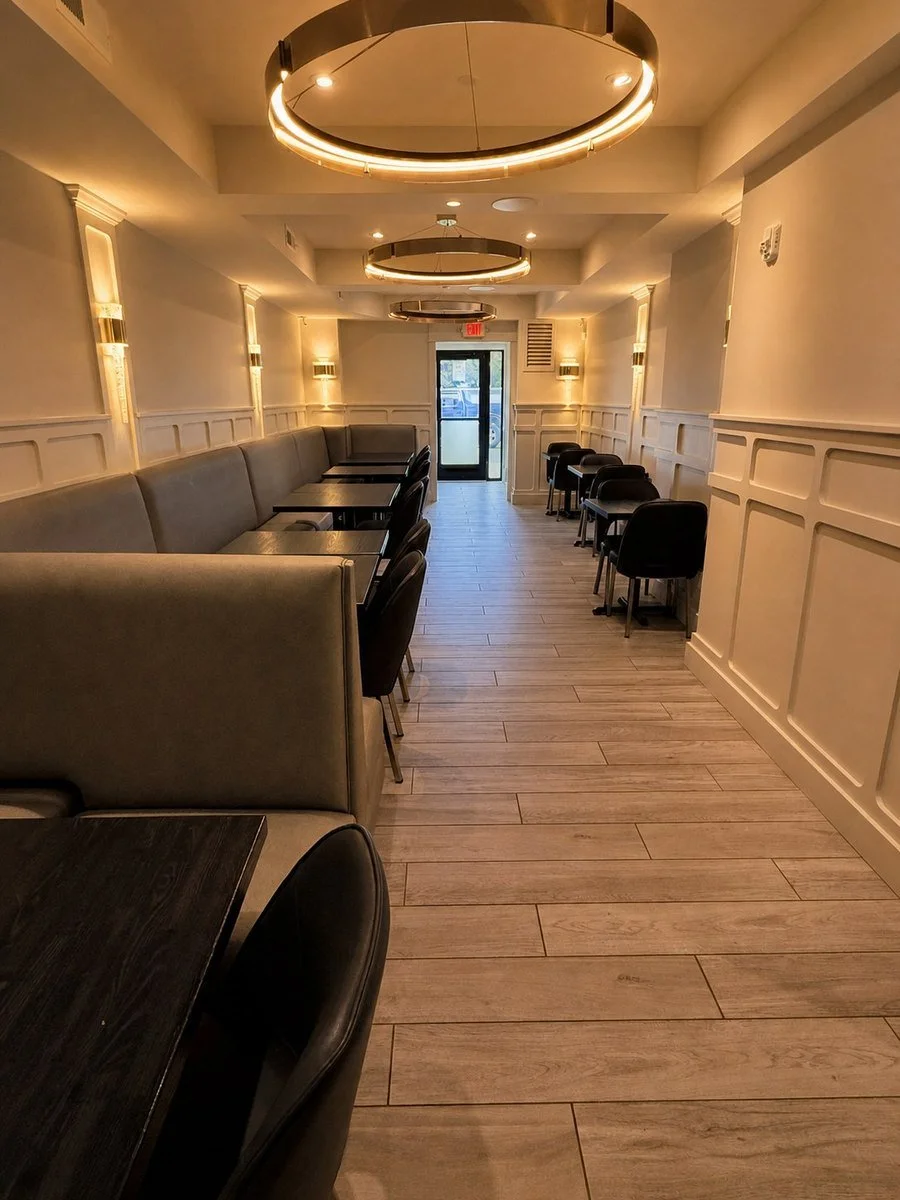 Florenza’s dining room with upholstered seating, warm pendant lighting, and cream wall paneling