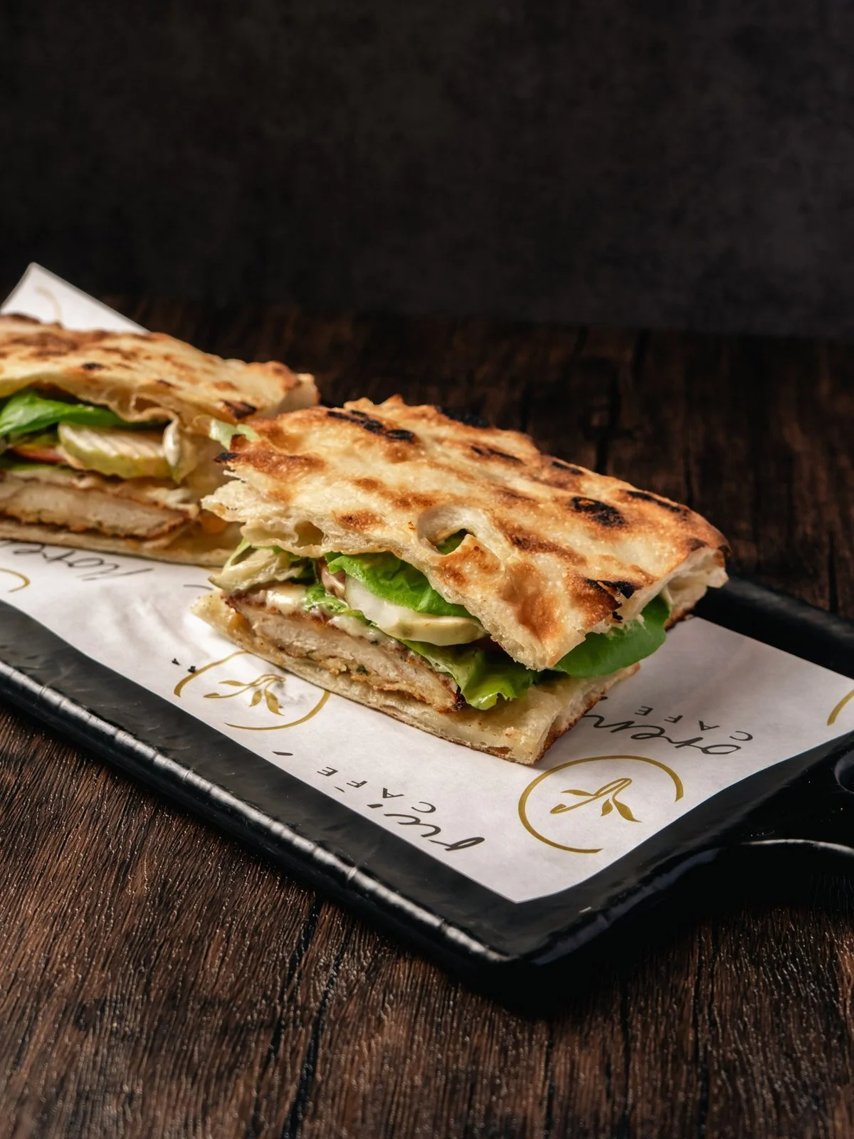 American chicken panini cut into portions on a Florenza-lined serving tray.