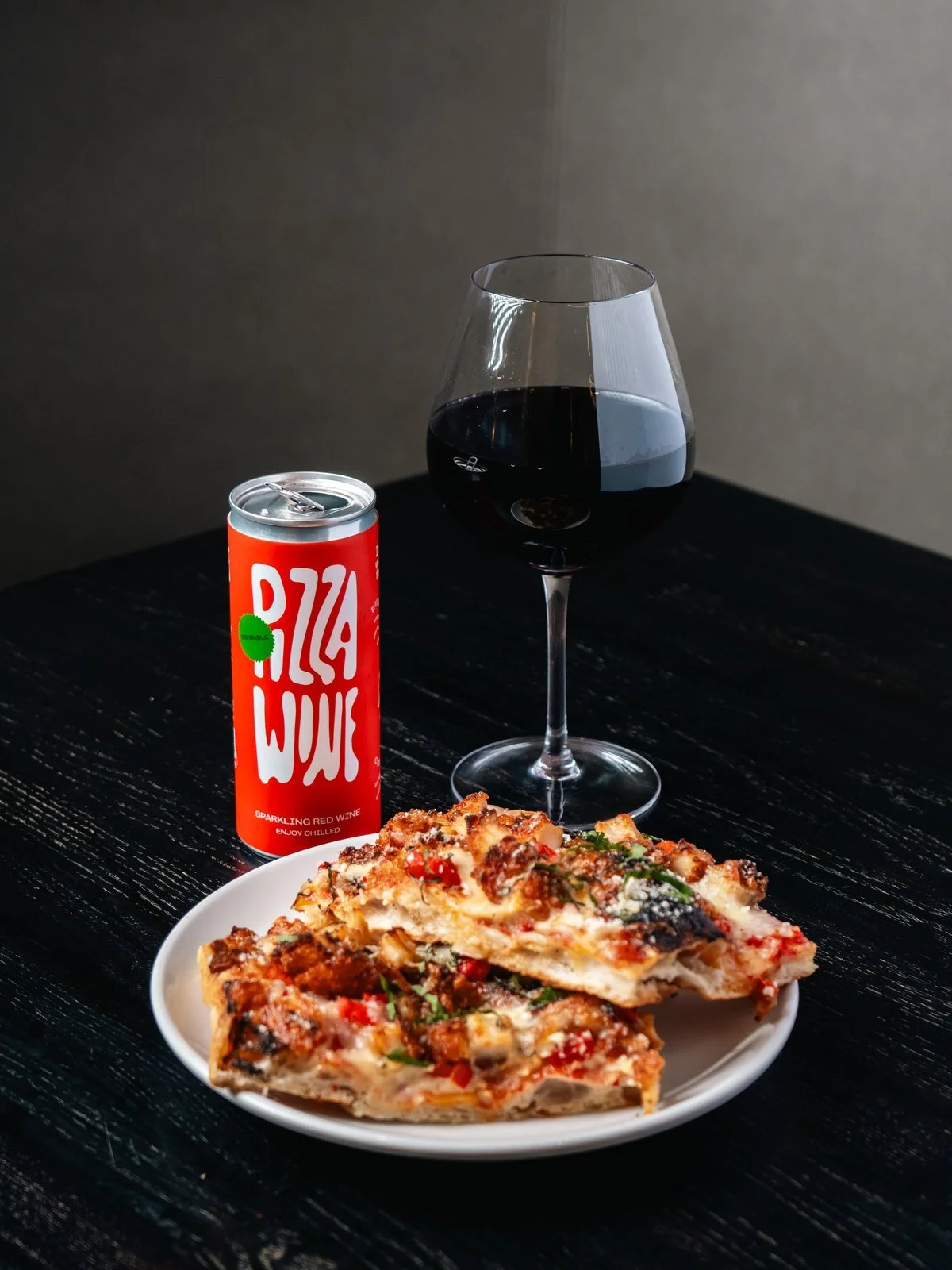 A glass of red wine, a can of Pizza Wine and a Roman-style slice at Florenza