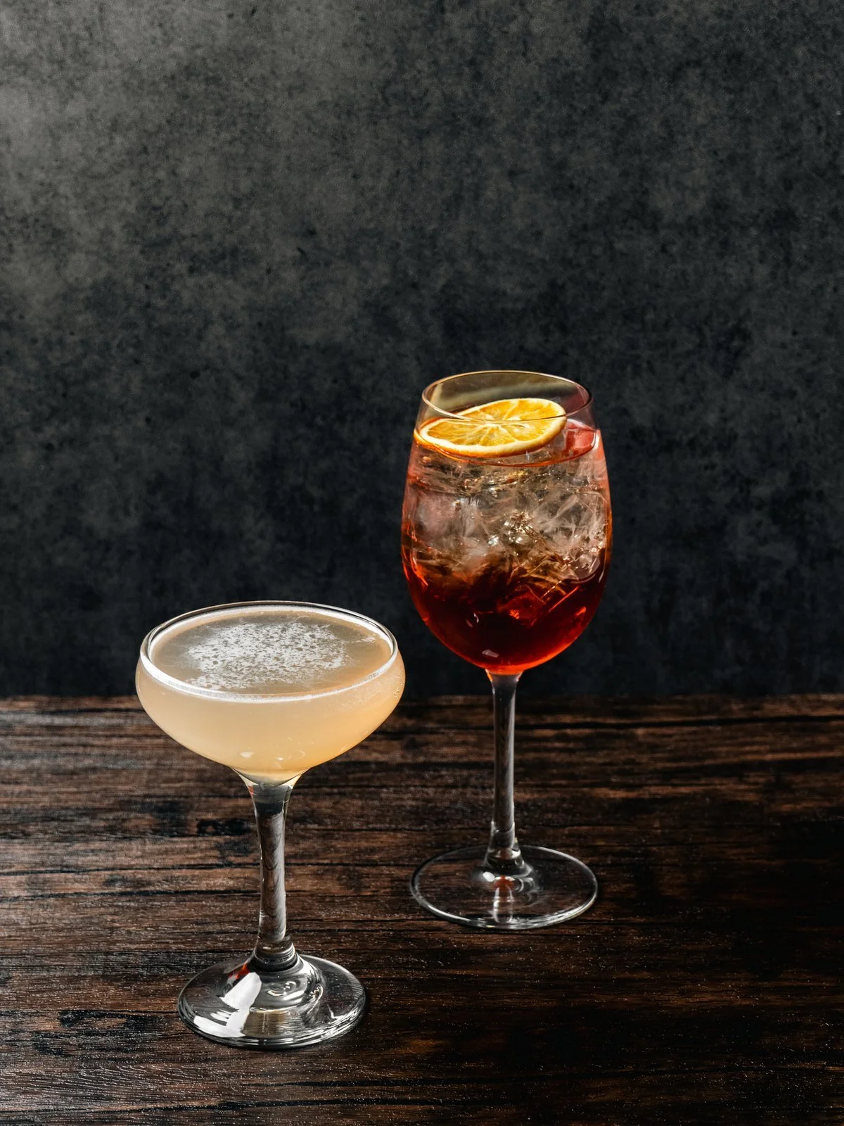Two cocktails on a dark wood table at Florenza