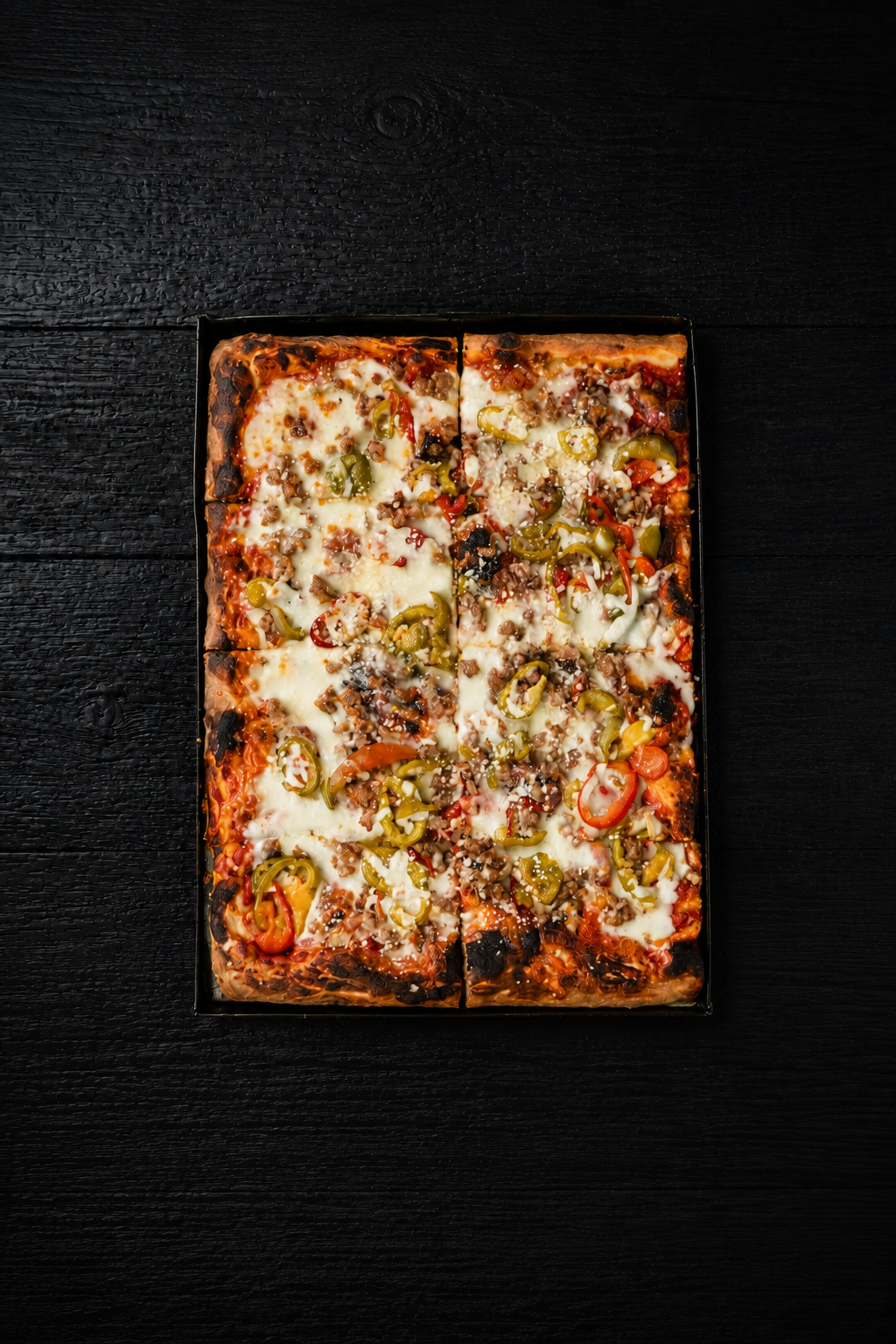 The Eastie Roman-style pizza with sausage and hot cherry peppers, photographed overhead.