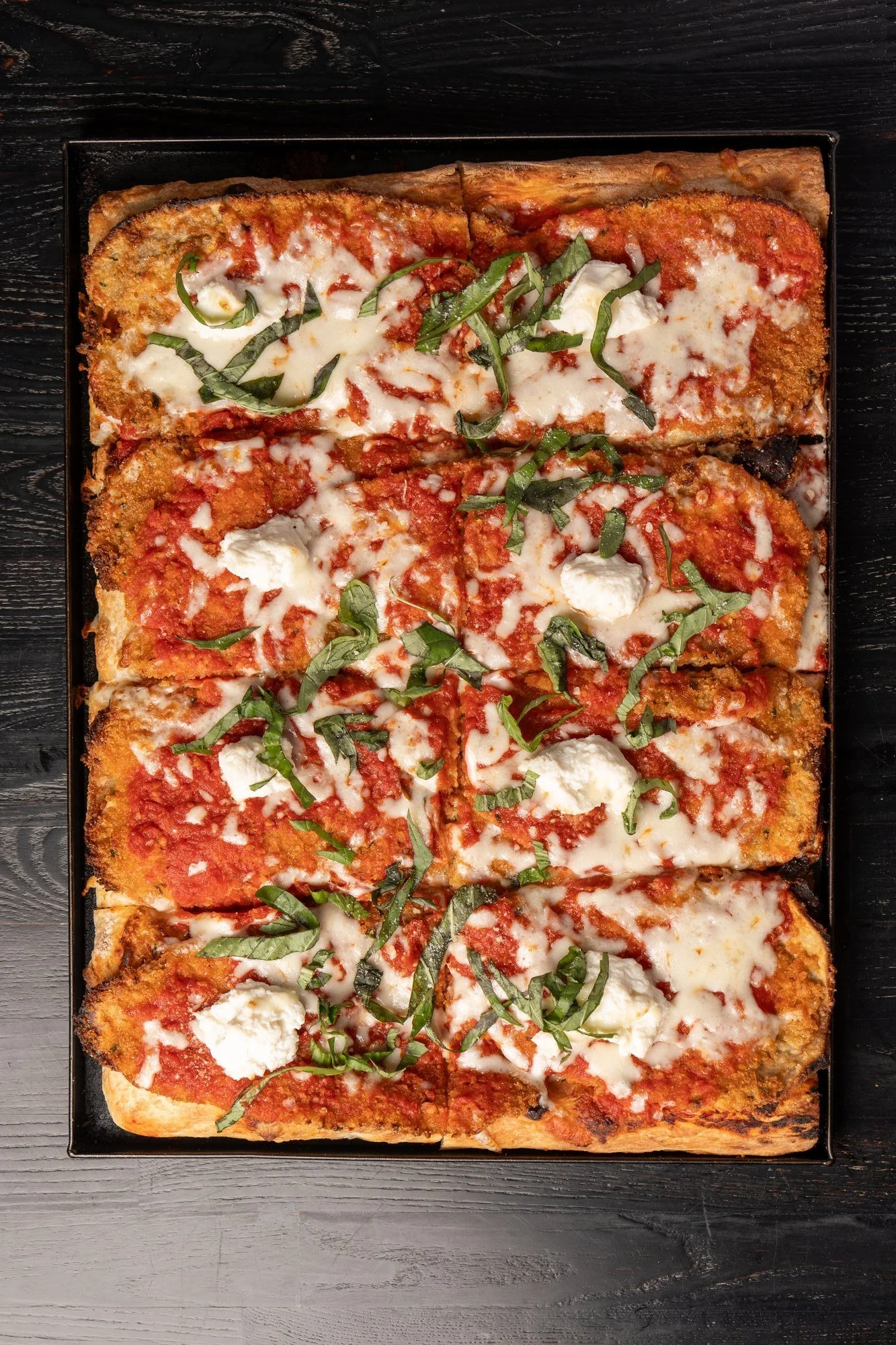 Eggplant Roman-style pizza with tomato sauce, cheese, and fresh basil.