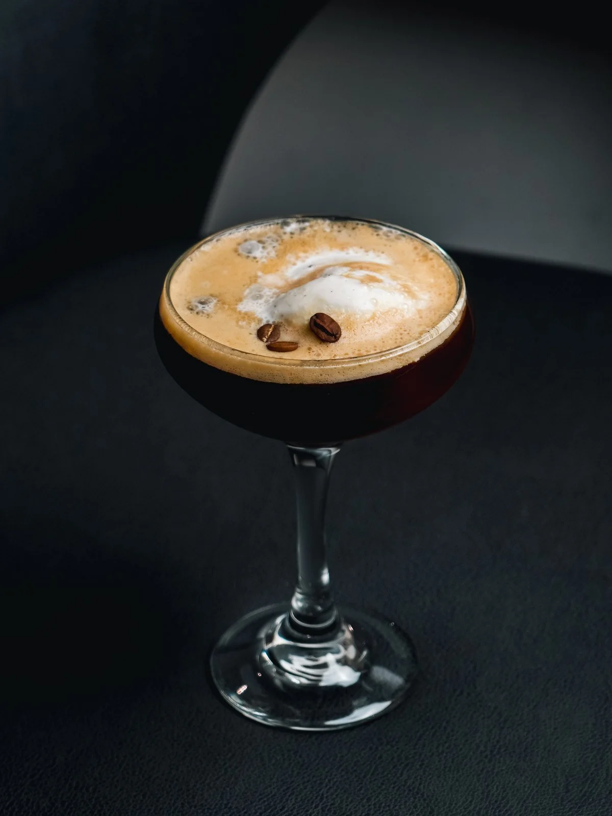 Espresso martini in a coupe glass topped with coffee beans