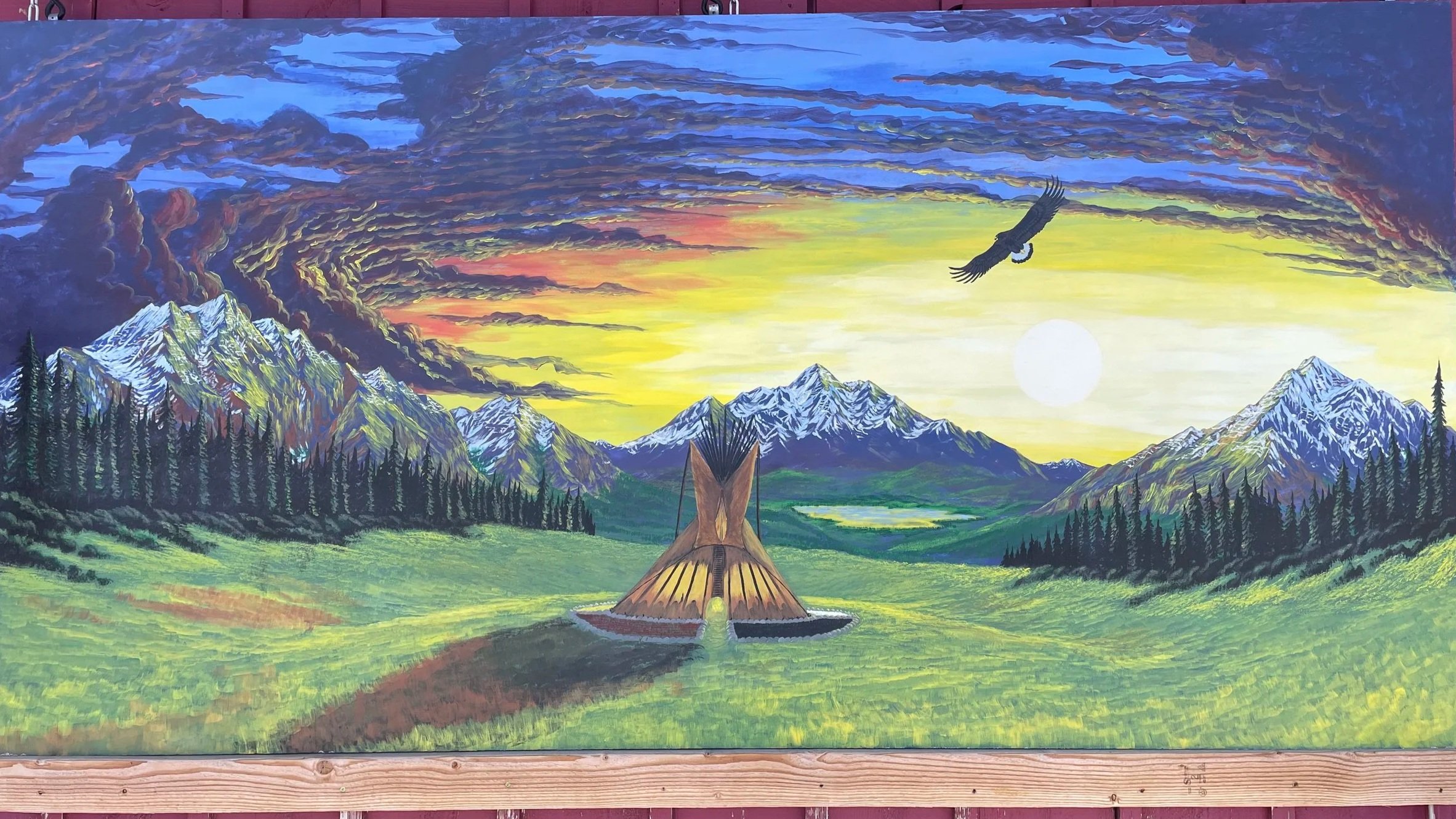Painting of a scenic mountain landscape with snow-capped peaks, lush green fields, dense pine forests, and a sunset sky with purple, pink, yellow, and blue clouds. A large bird is flying above, and a wooden structure resembling a tent is in the foreground.
