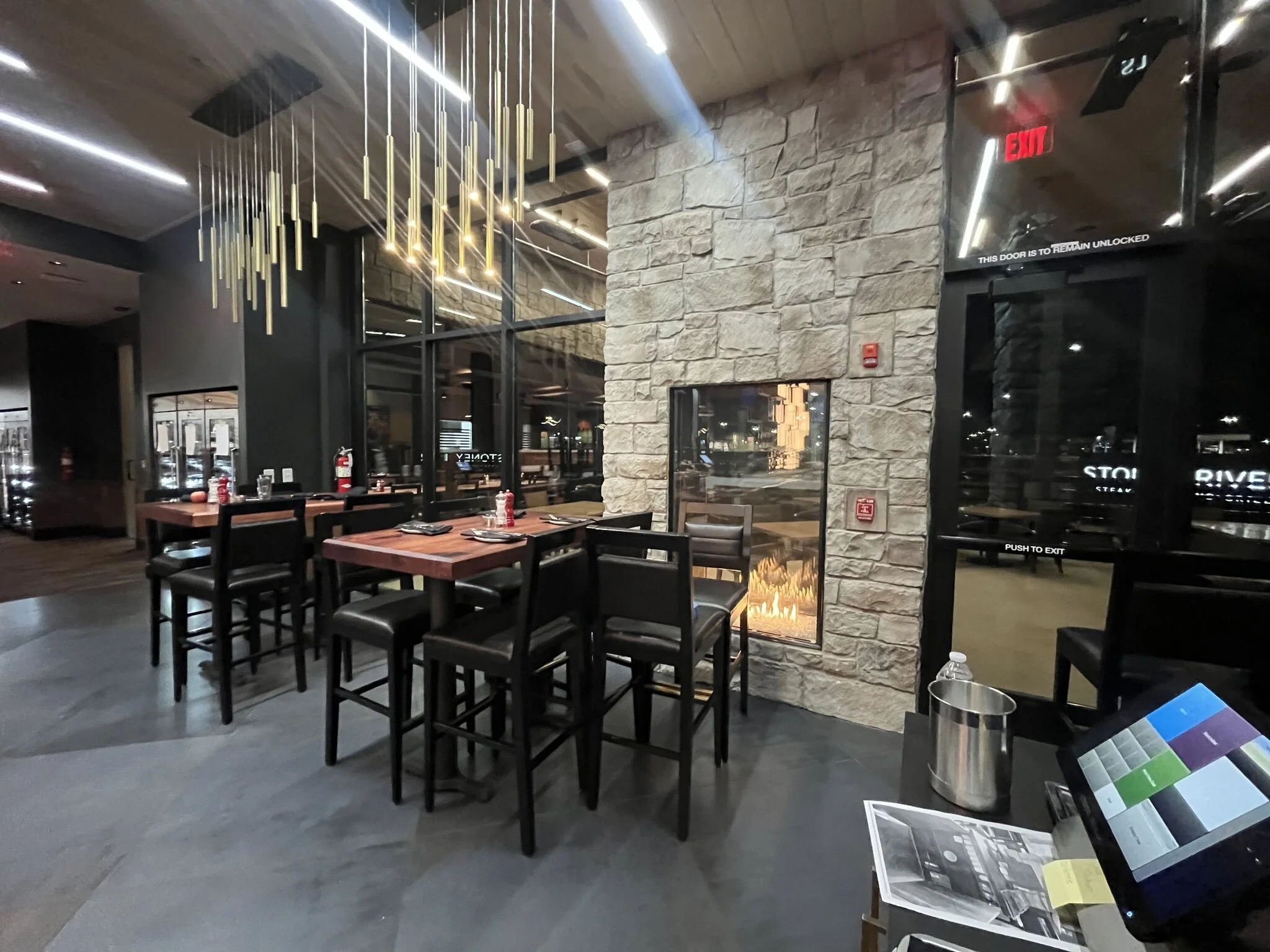 Interior view of dining area high top tables, chairs, sexy fireplace #stoneyriver