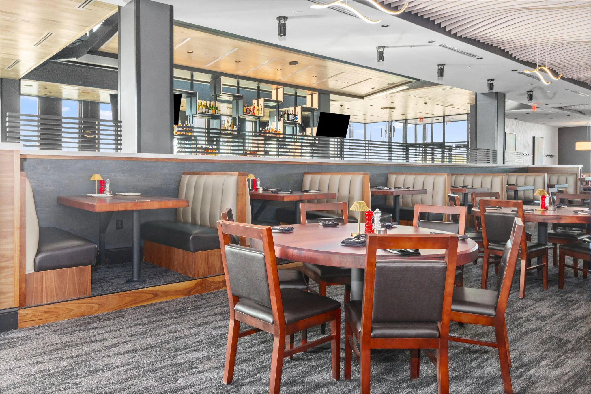 Interior view of dining area tables, chairs, booths, cool wave panel ceiling. Great bar in the background #stoneyriver