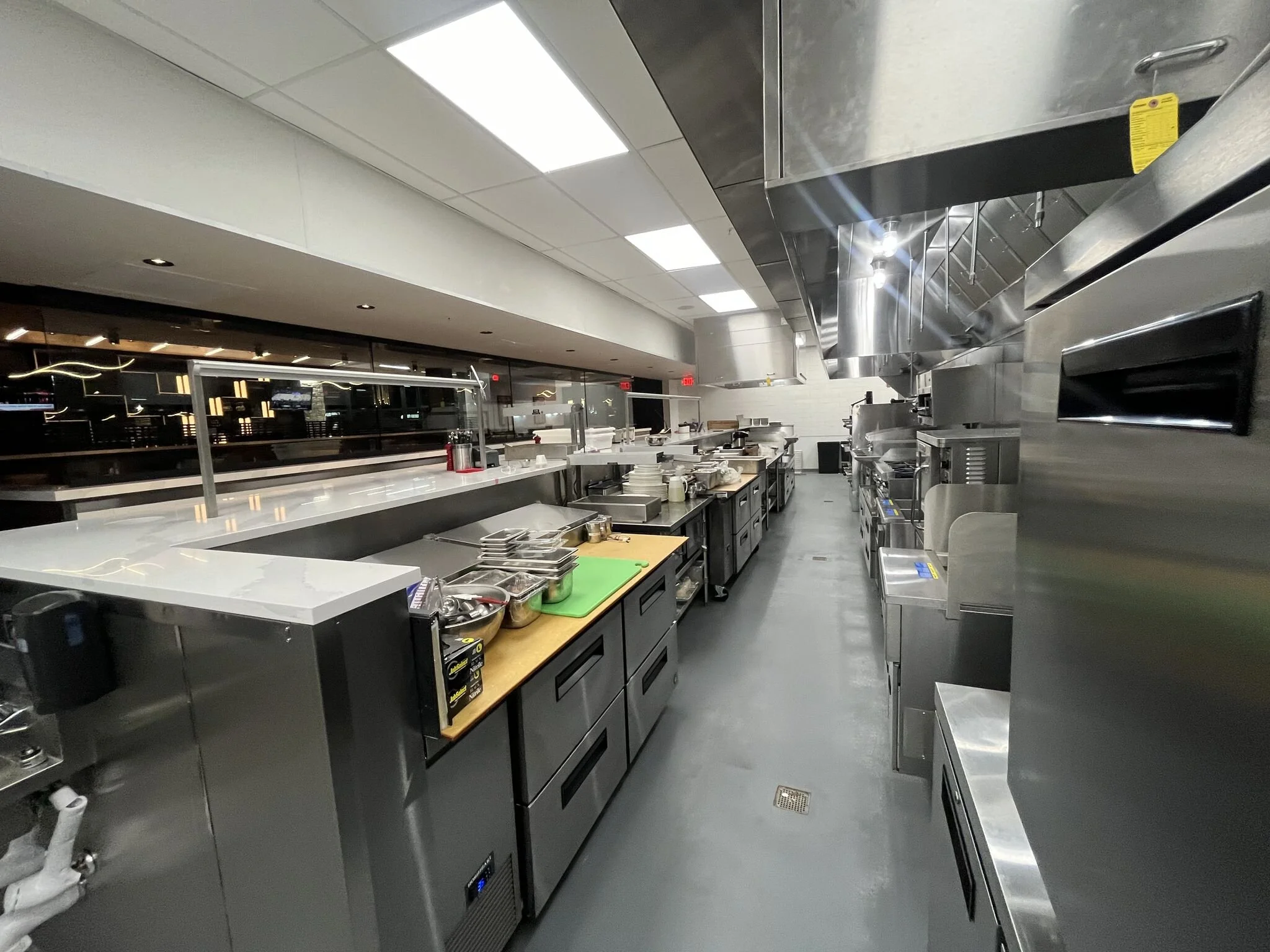 Interior view of kitchen area showcasing an organized line of stainless steel equipment and prep area #stoneyriver
