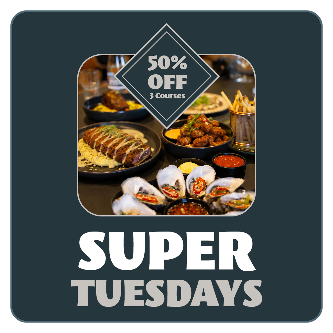Overlay promoting Super Tuesday with a photo of various dishes including fried fish, French fries, a burger, sushi, grilled meat skewers, and dipping sauces on a black table.