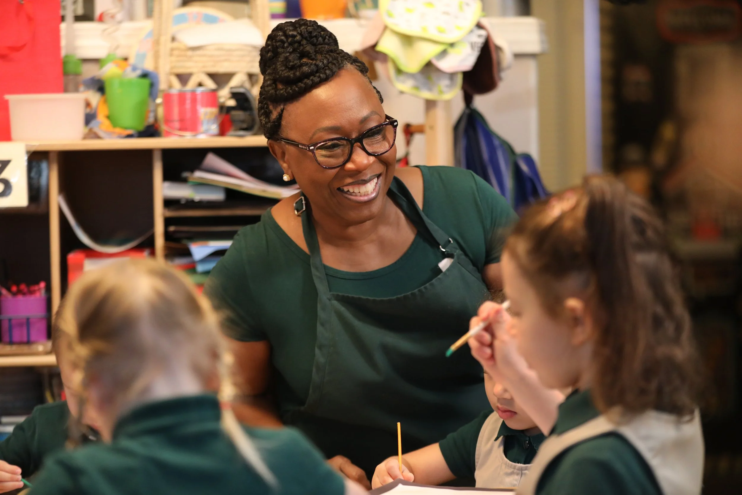 Woman in glasses providing childcare to young children