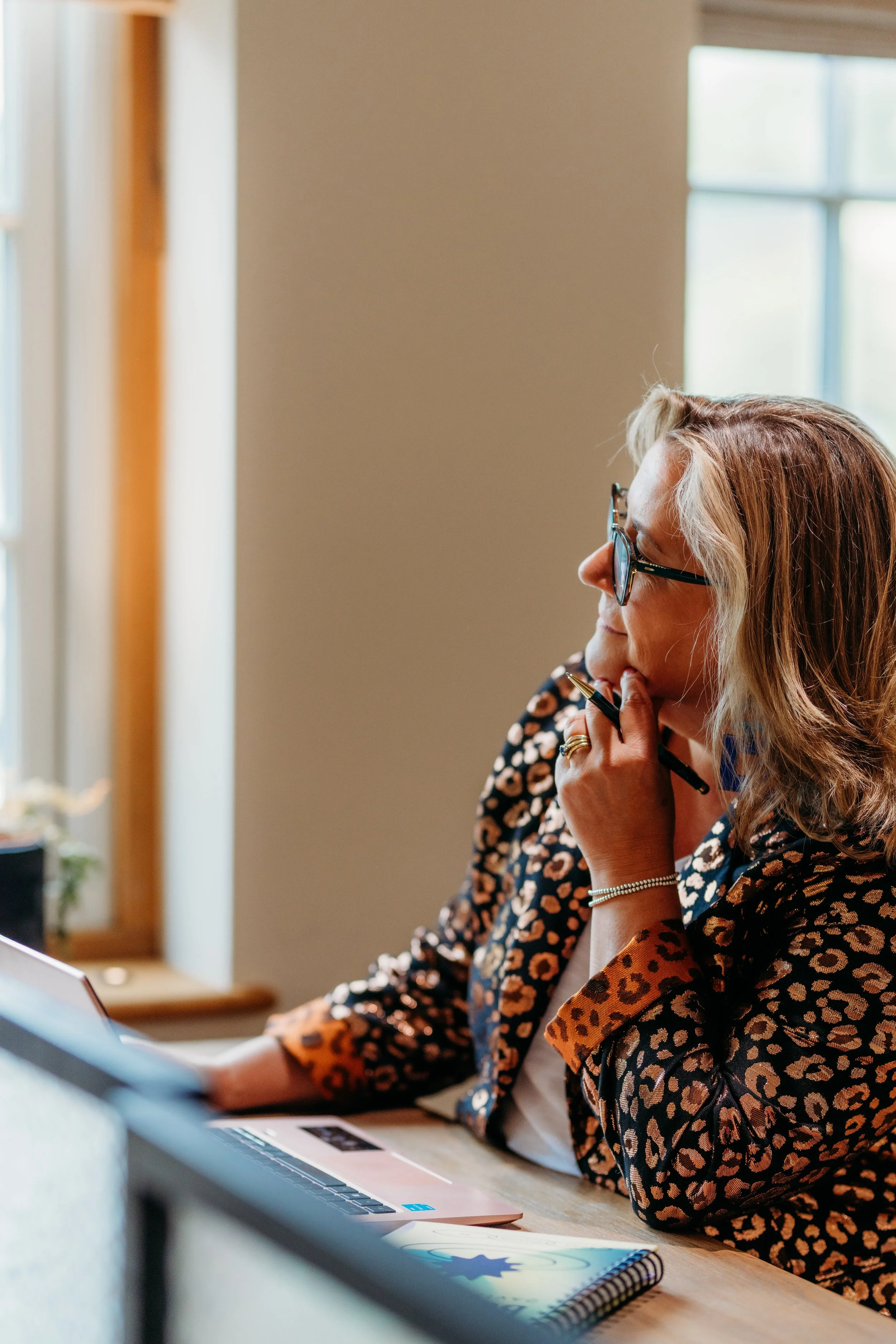 Bobby sitting at her desk looking out of the window reflecting on What Next?