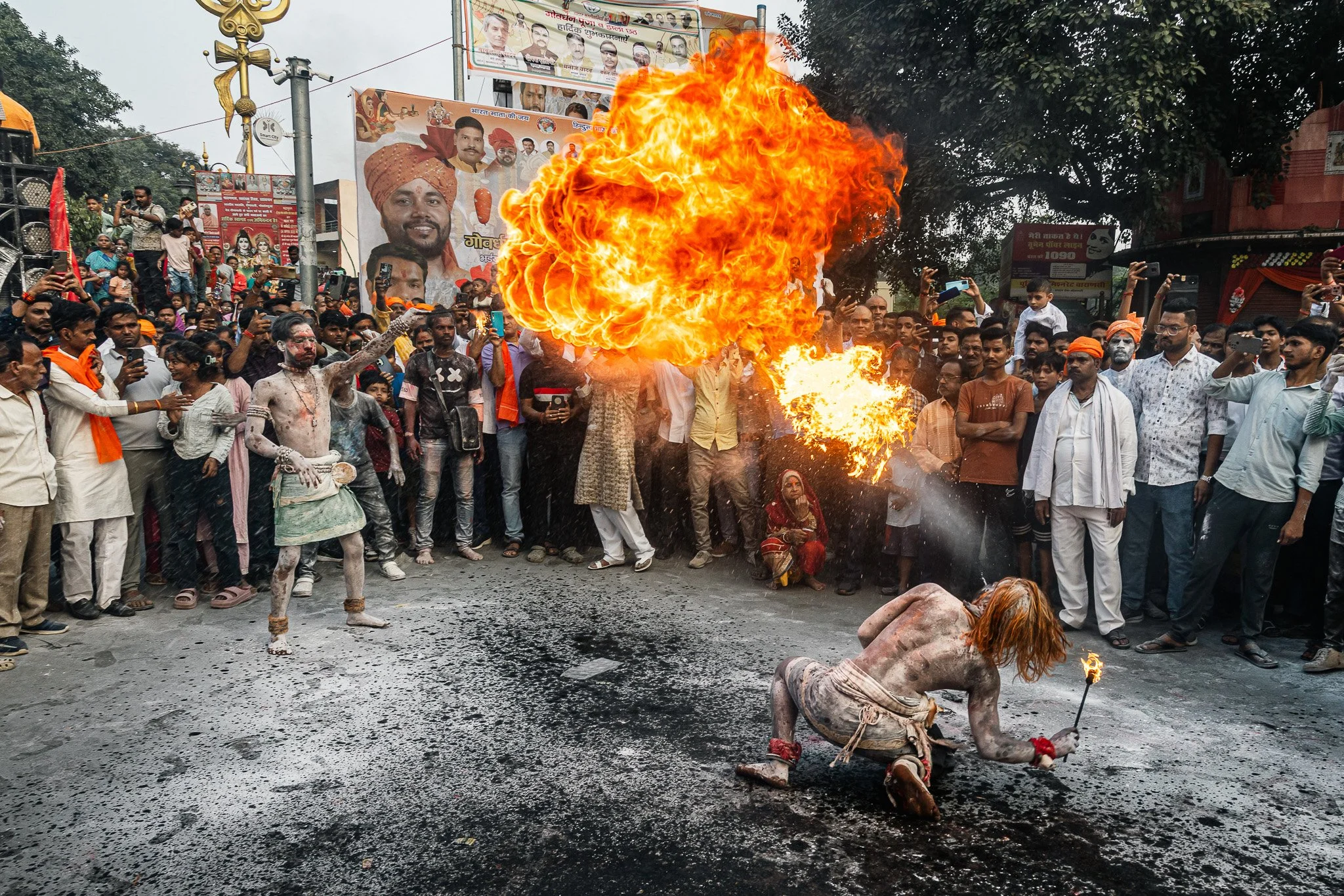 image of fire breathers spitting a cloud of fire in the streets of varanasi