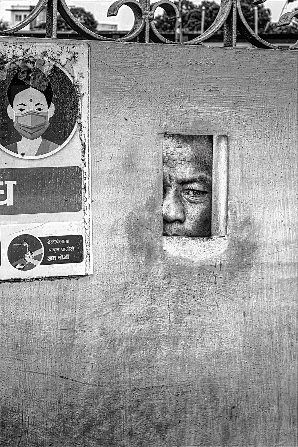  A police officer peers through a gate opening.