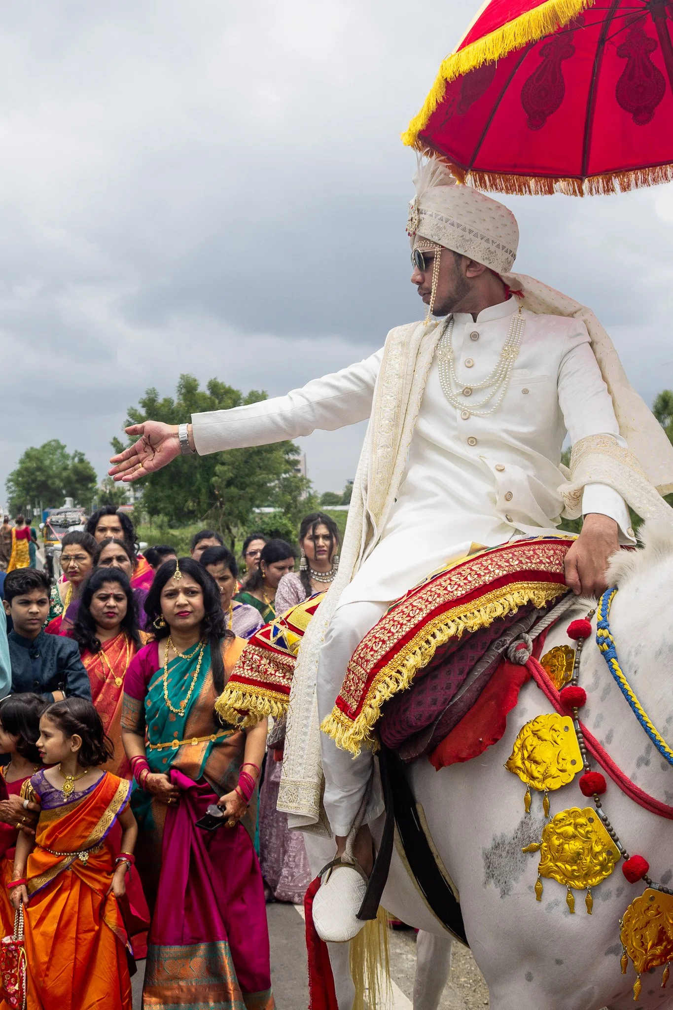 Tushar rides proudly on horseback as he leads the traditional wedding procession to the ceremony venue, embodying the regal customs of his Indian wedding celebration.