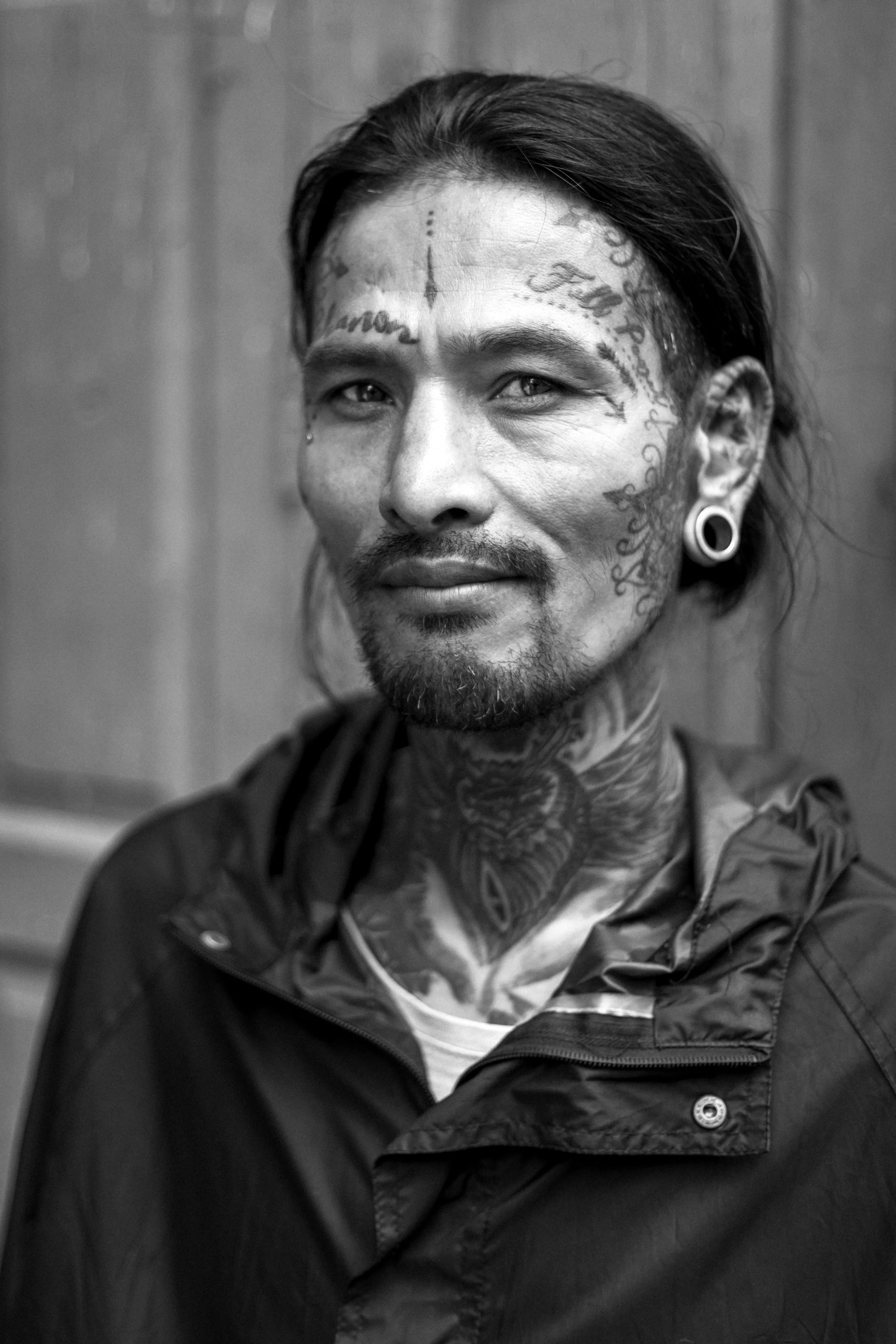 Saroj displays his distinctive facial tattoos in this striking street portrait, his bold artistic choices and intense gaze creating a powerful study of individual expression.