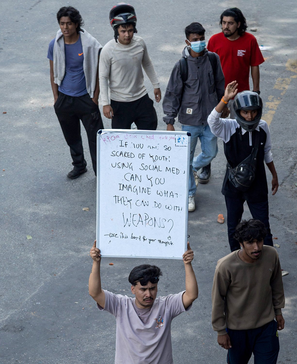 [Act I: Assembly]. A protester carries a message board, foreshadowing the confrontations to come.