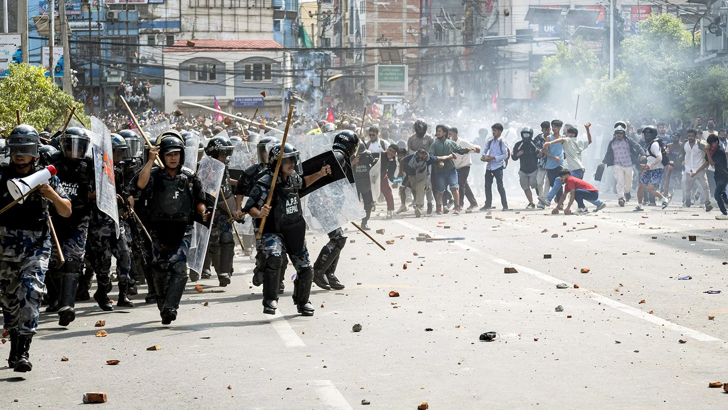 Police retreat under a barrage of stones.