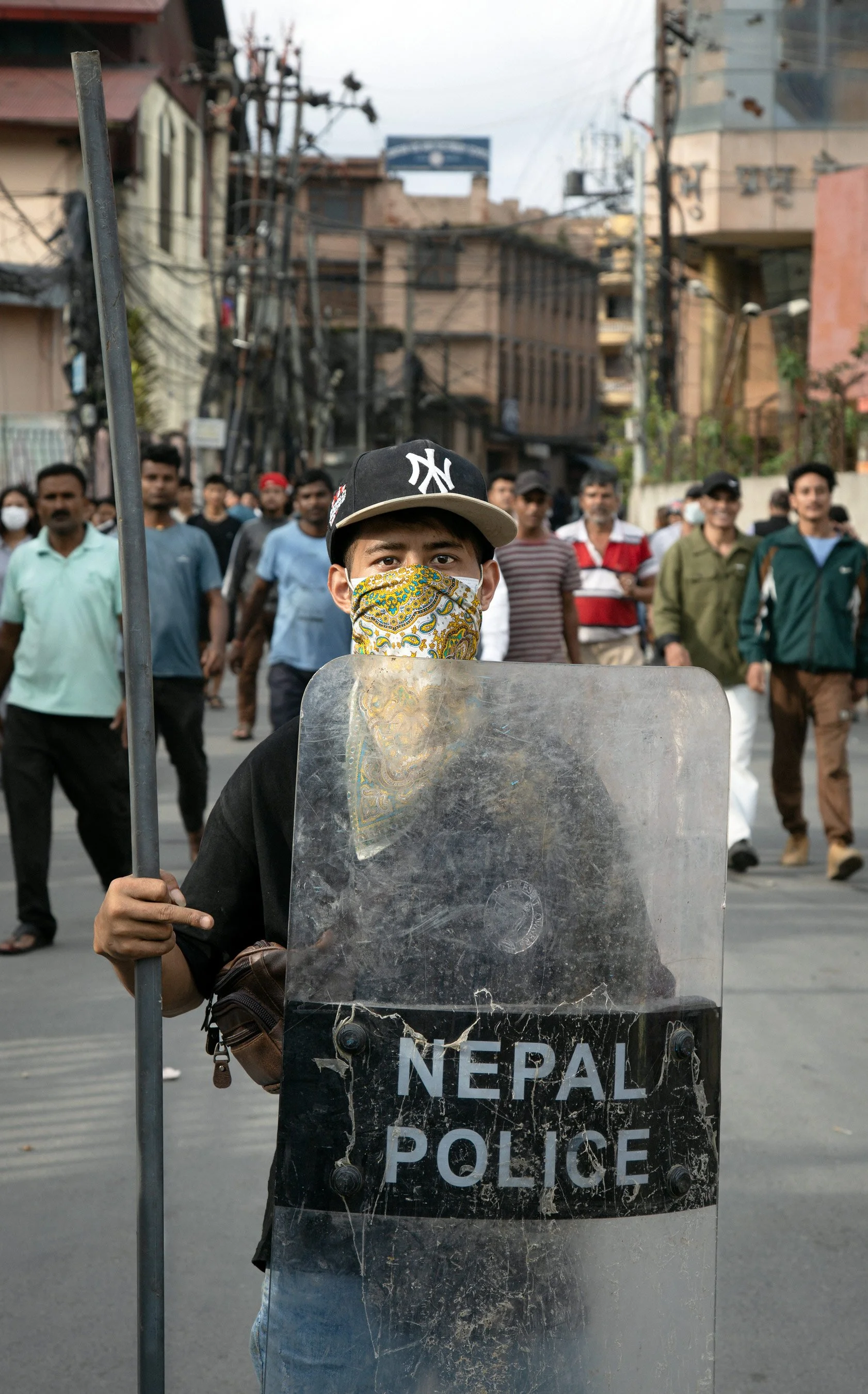 A protester in Kathmandu displays a police shield acquired during demonstrations, September 2025.