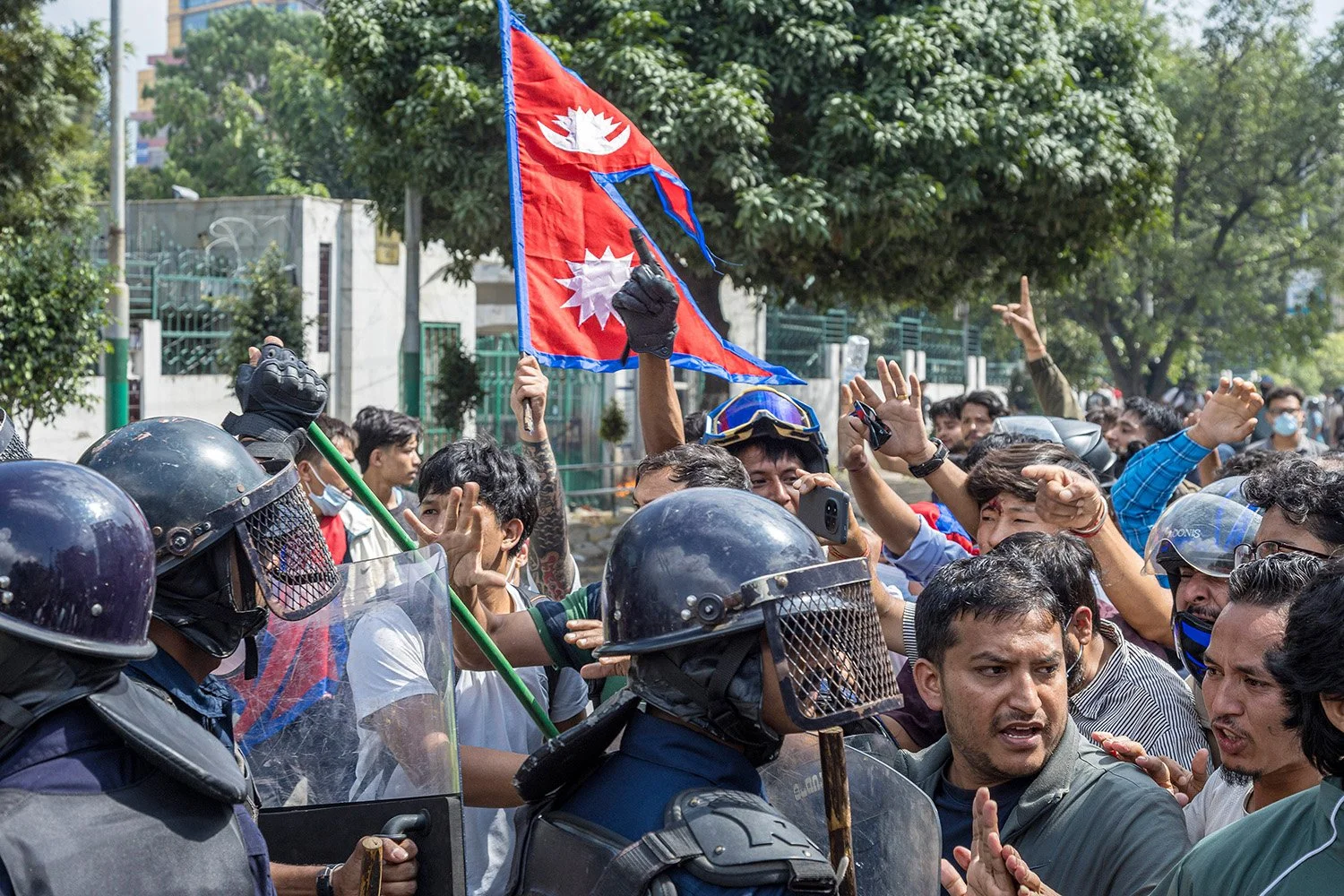 [Act I: Assembly]. The Nepali flag stands tall amid the collisions.