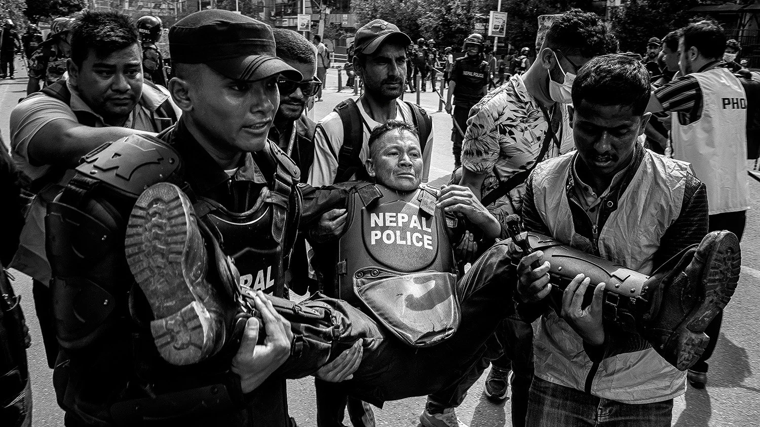 policeman carried away by journalists during the protest