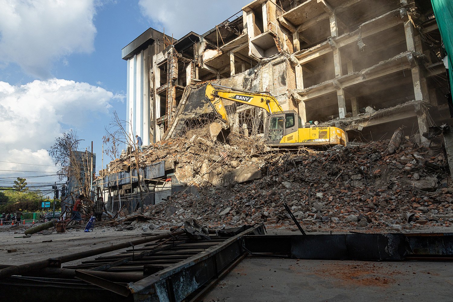 [Act III: Aftermath]. Rebuilding Begins: Debris removal from fire-damaged store.