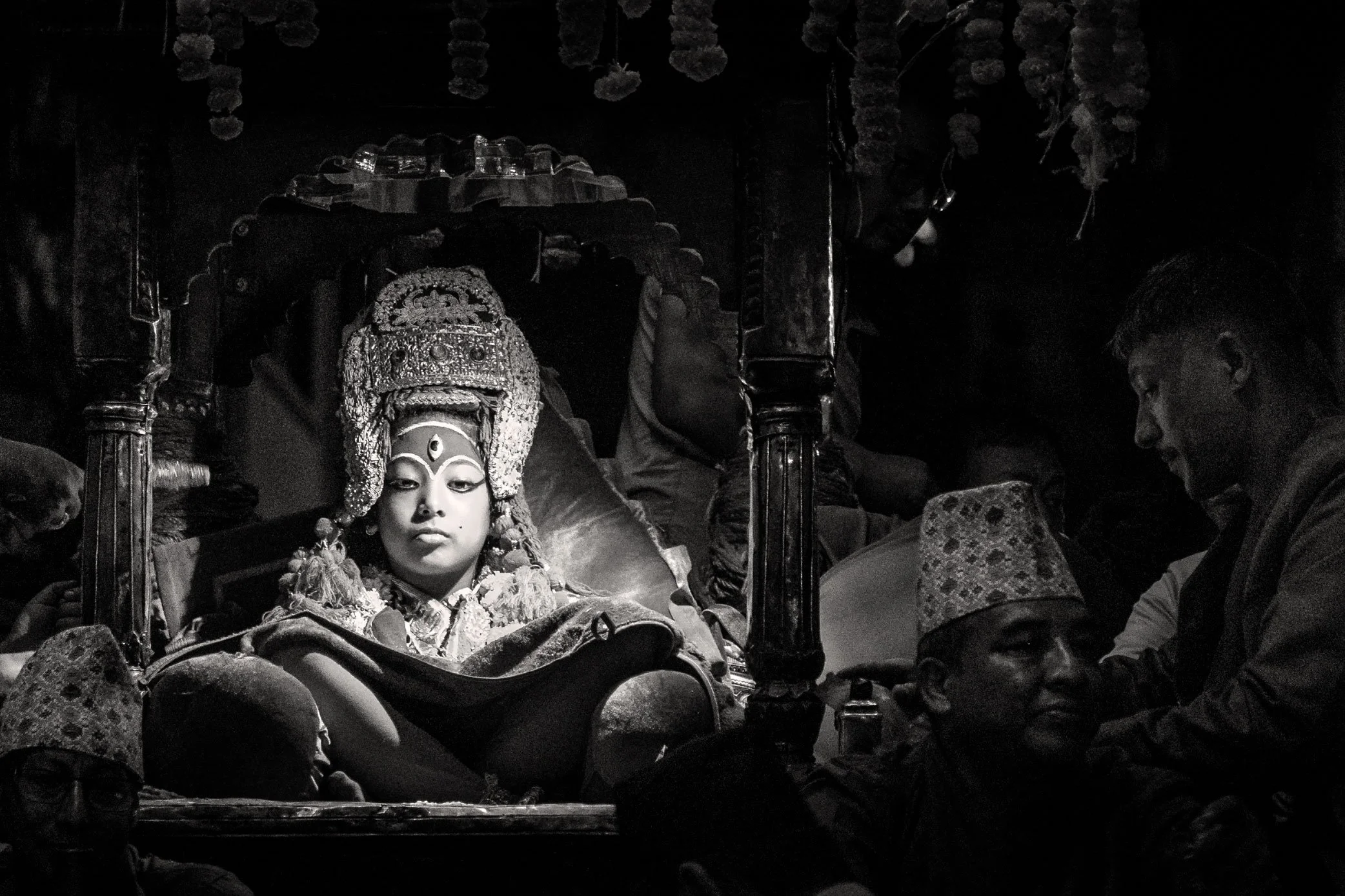 The Kumari sits in her elaborate ceremonial chariot as devotees pull the living goddess through the streets of Kathmandu during the revered Indra Jatra festival procession.