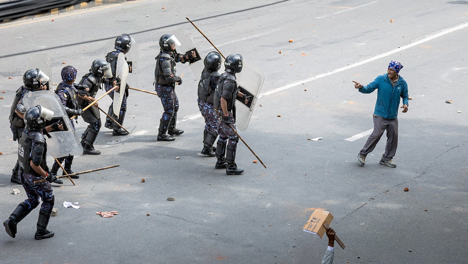 [Act I: Assembly]. Police charge toward a protester
