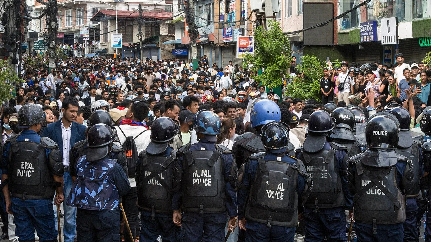 [Act I: Assembly]. Police stand outnumbered by the surging crowd.