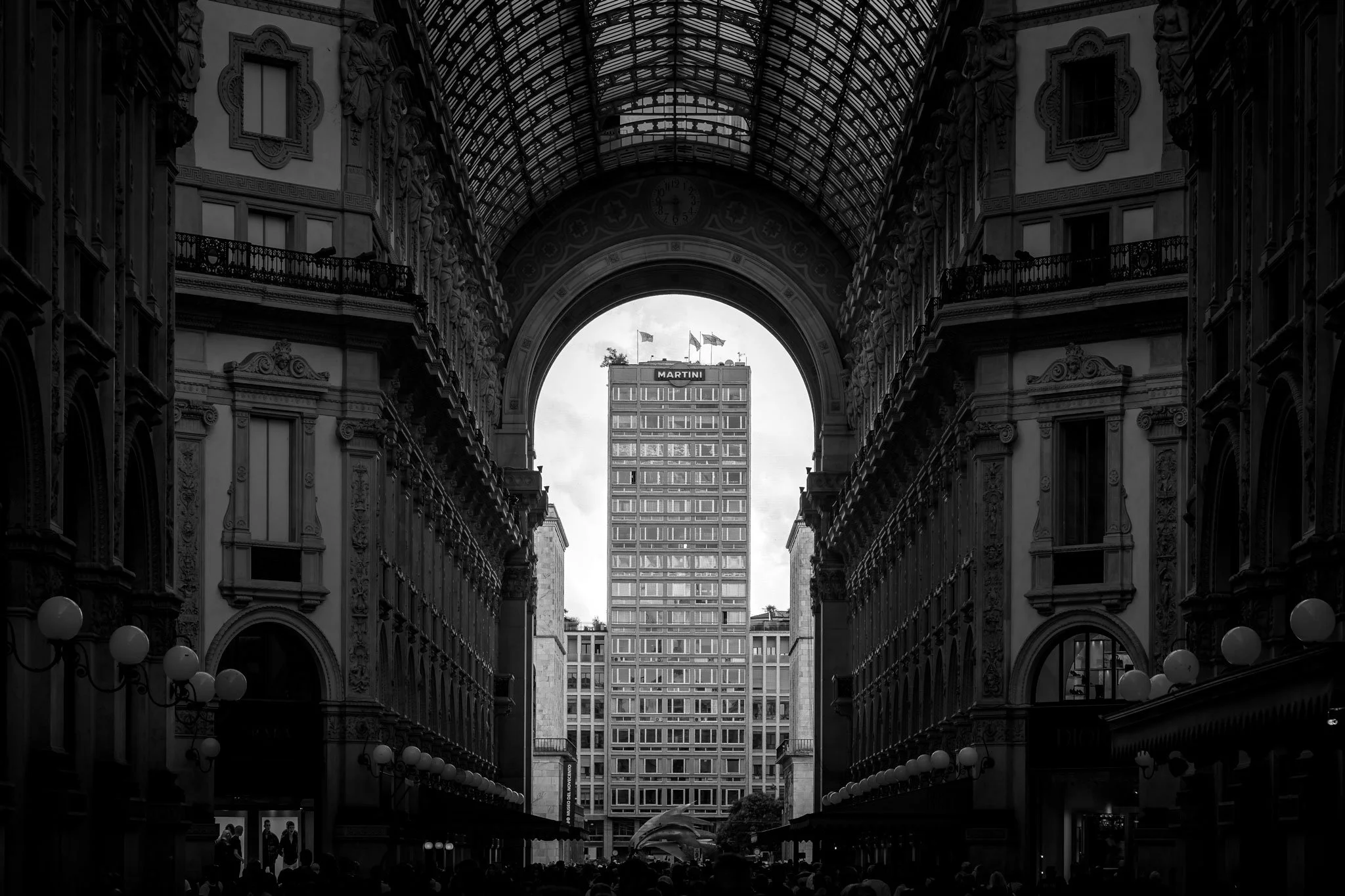 The distinctive Martini building rises prominently along Corso Vittorio, its iconic architecture commanding the urban skyline.