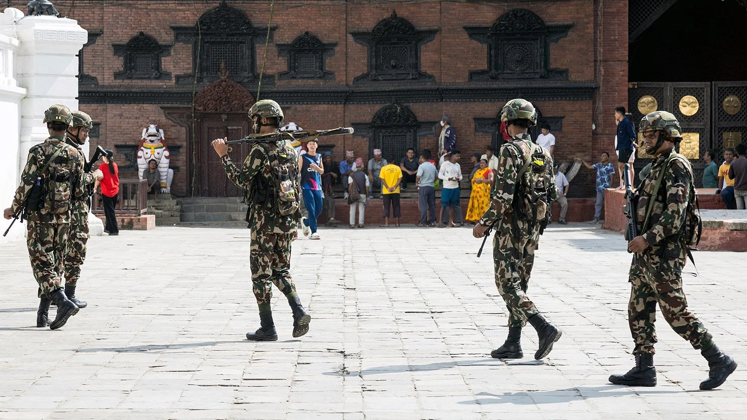 [Act II: Collision]. Army units march through Durbar Square.