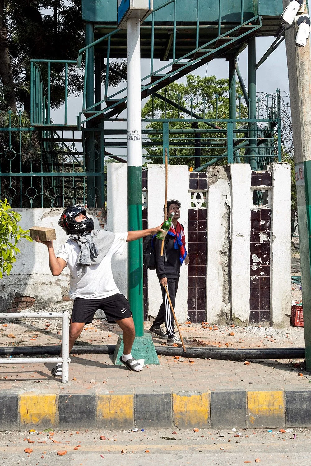 [Act I: Assembly]. A protester attempts to destroy surveillance cameras in front of the Parliament.