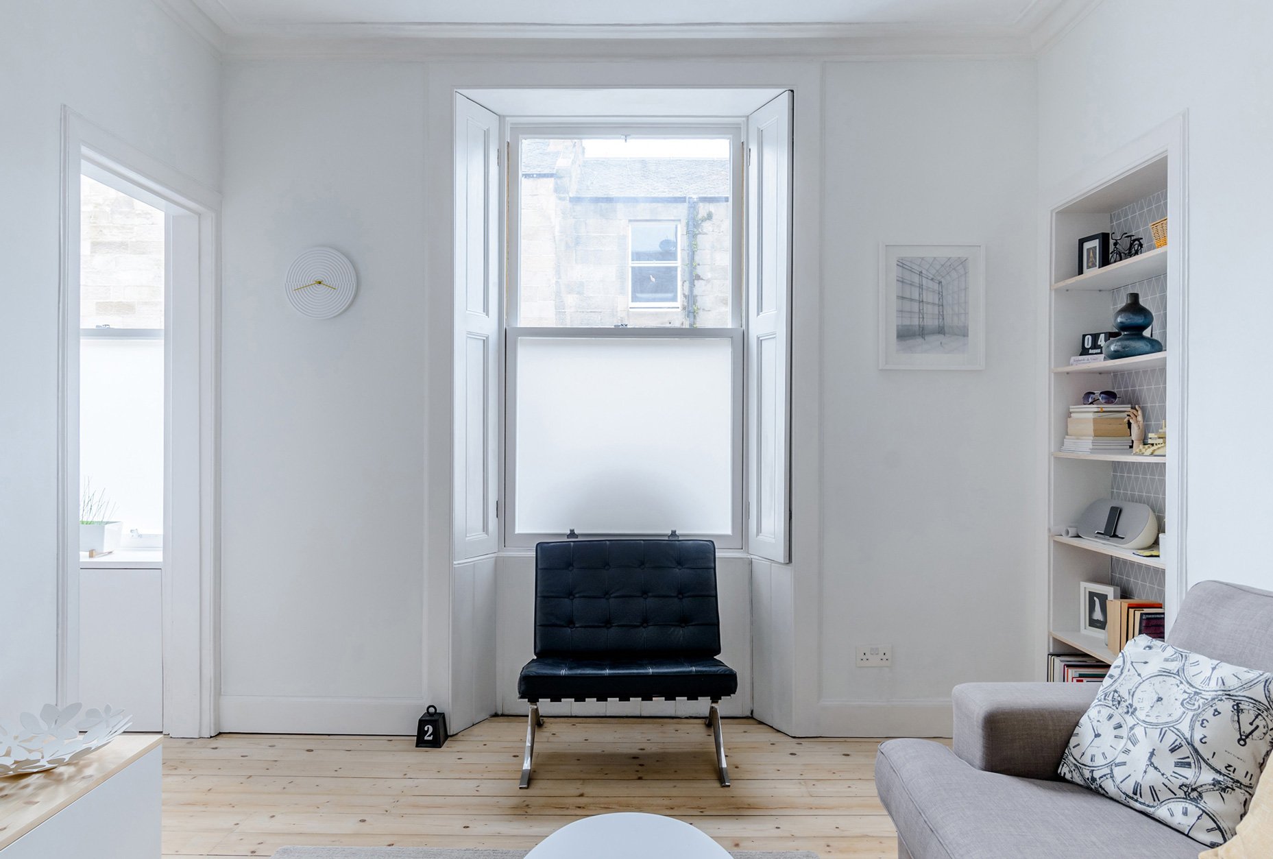 Modern interior architecture of a lounge space with wooden floor and white walls.