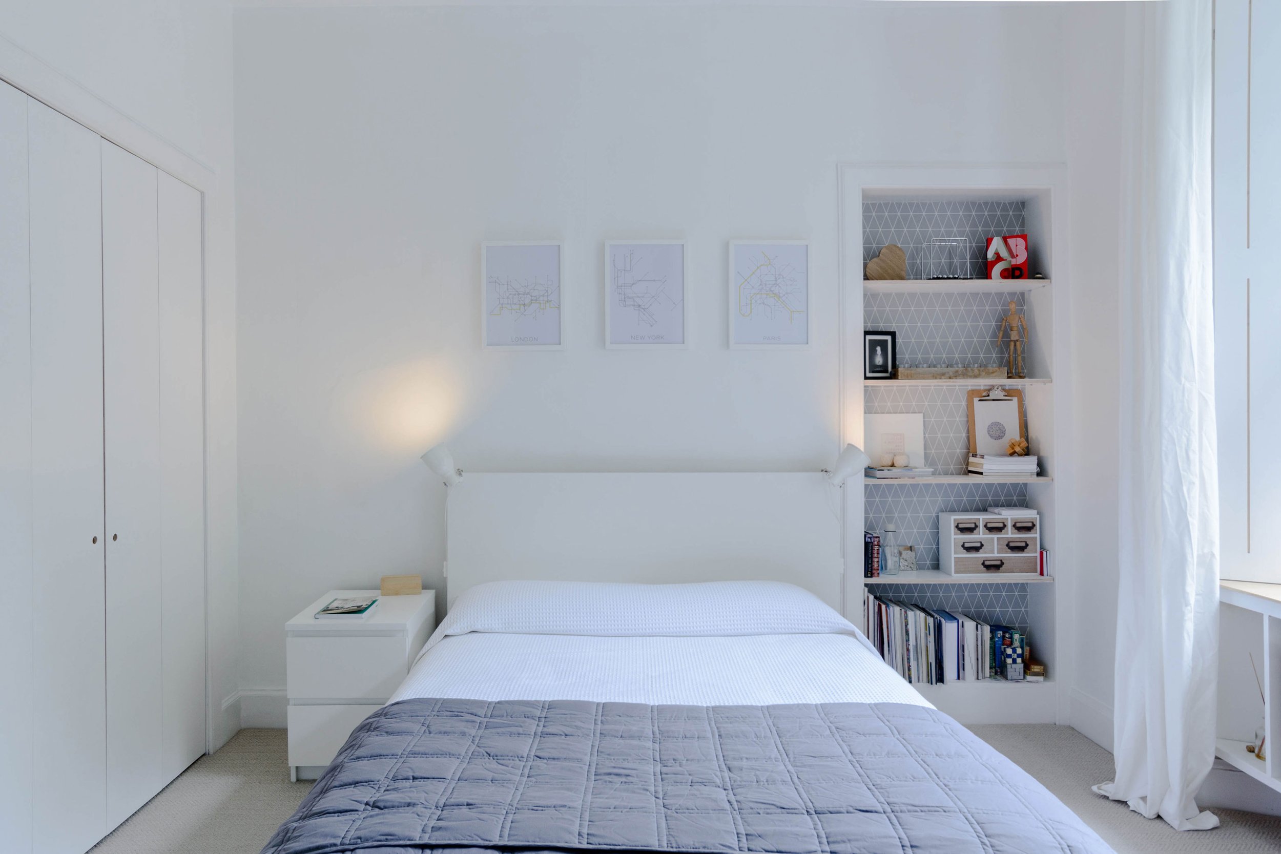 Modern interior architecture of a bedroom space with neutral carpet and white walls.