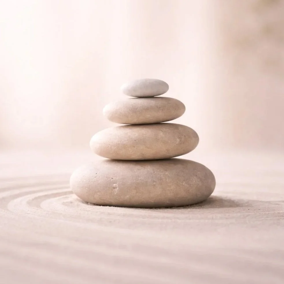 Galets empilés en équilibre symbolisant l’harmonie et l’équilibre intérieur – soins Sérénisens