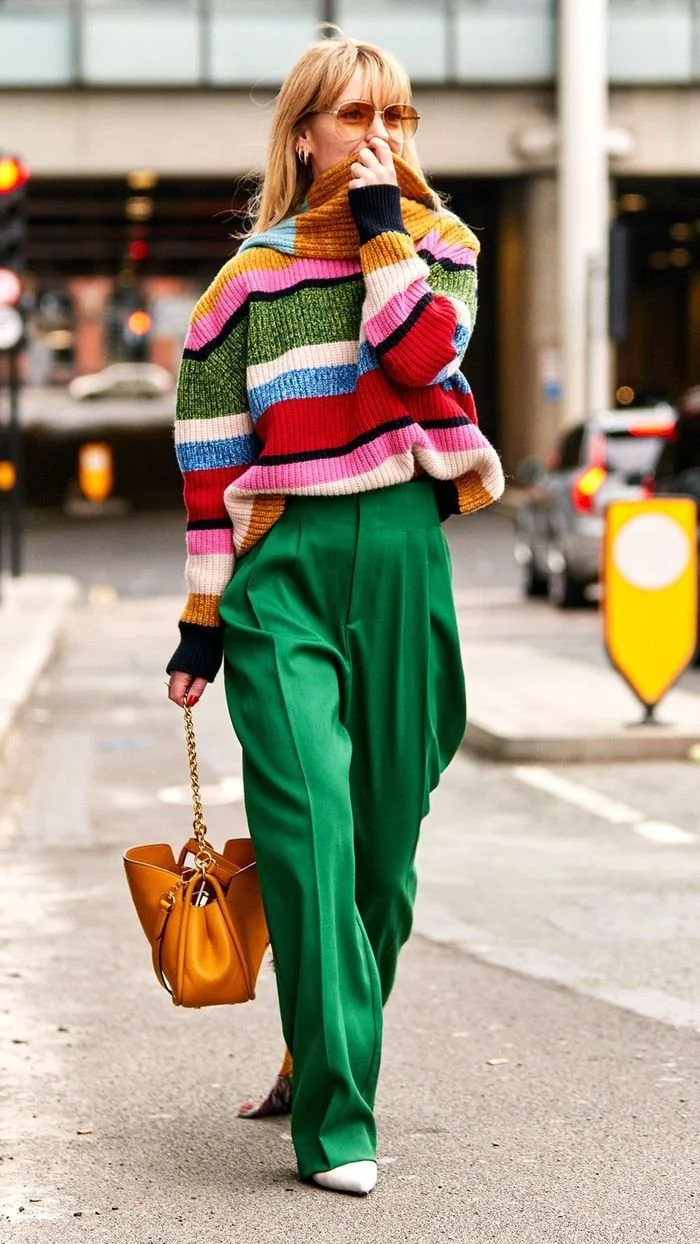 woman wearing multi colored sweater and green pants