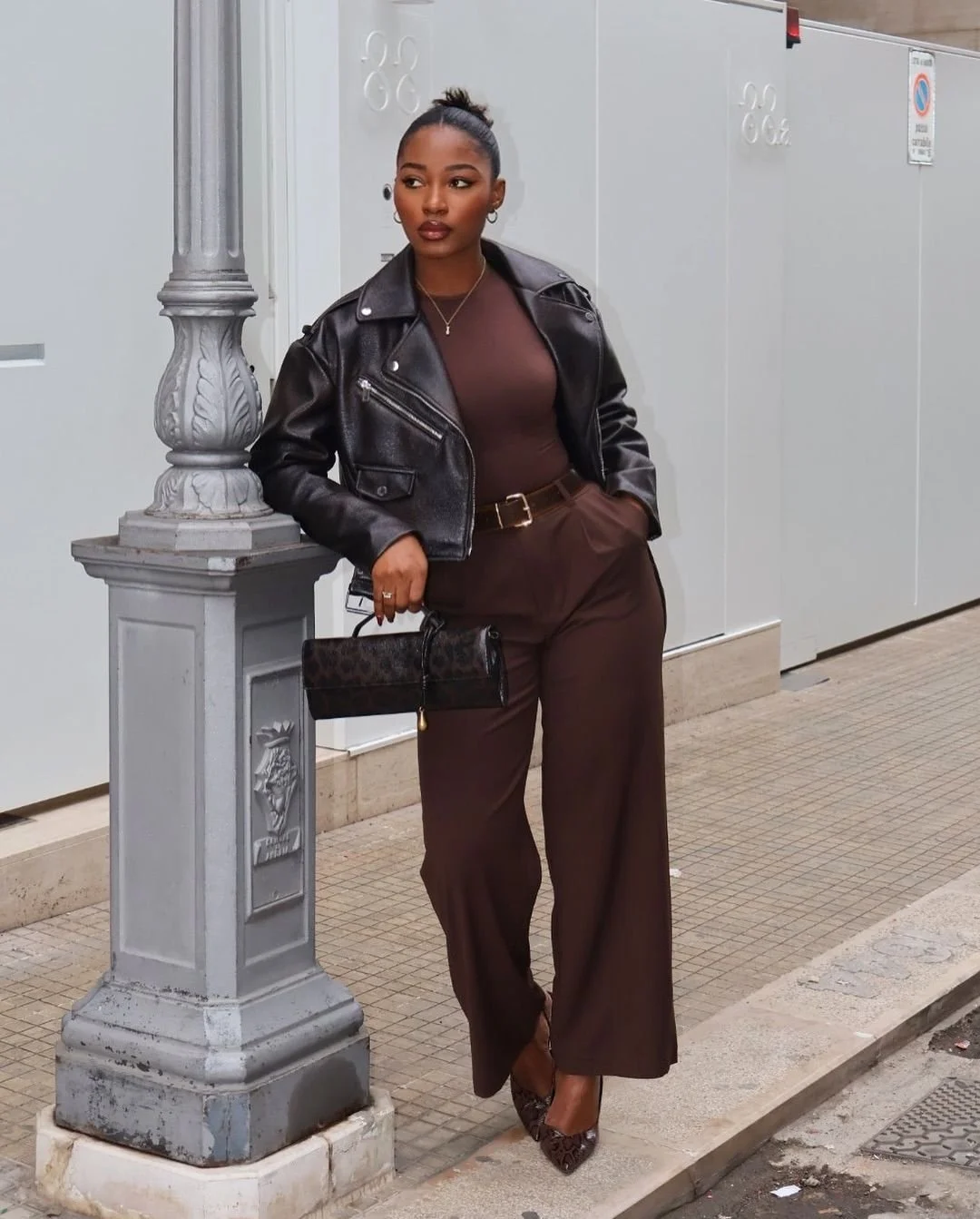 woman wearing a brown jump suit and leather jacket