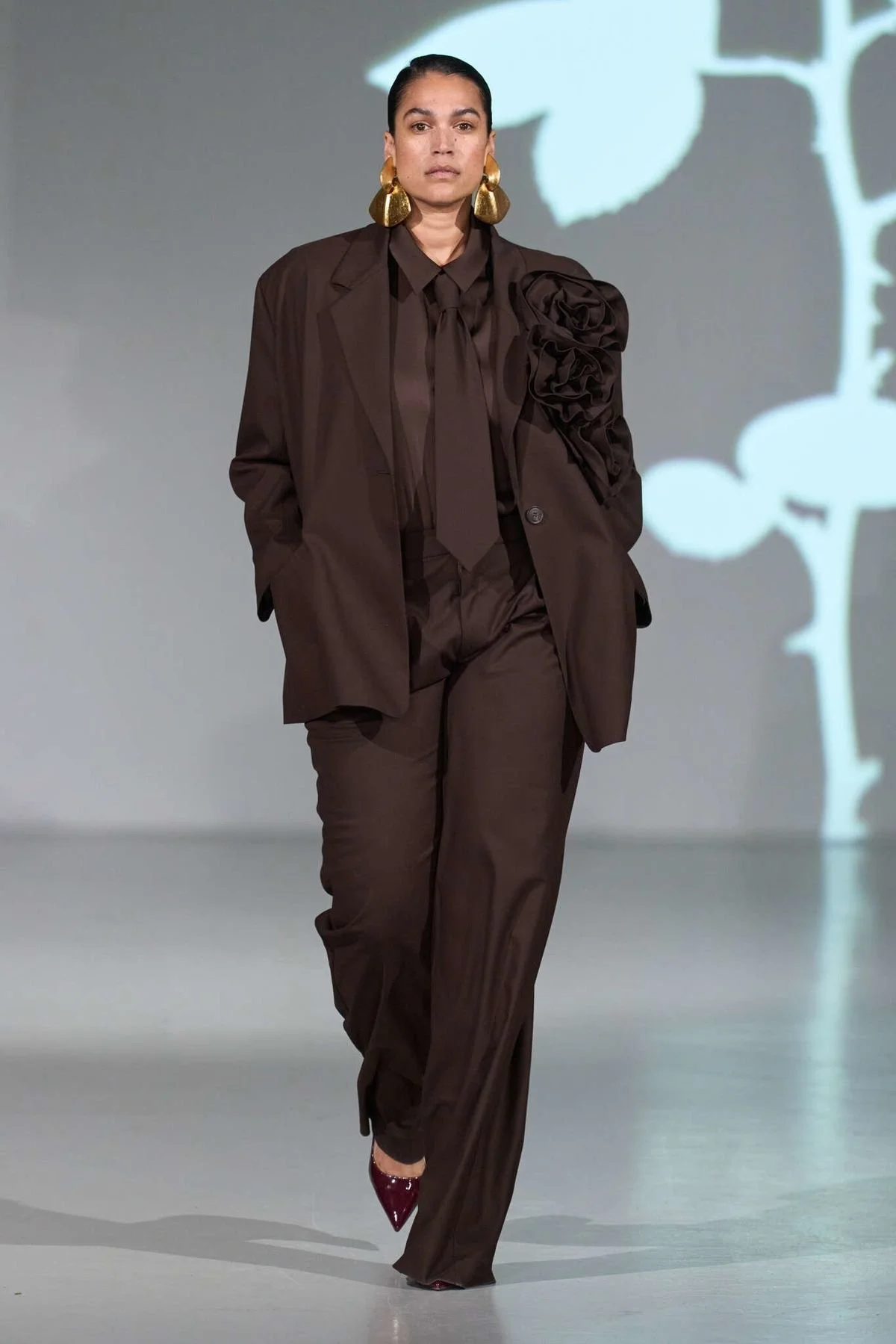 woman wearing brown blazer and suit trousers