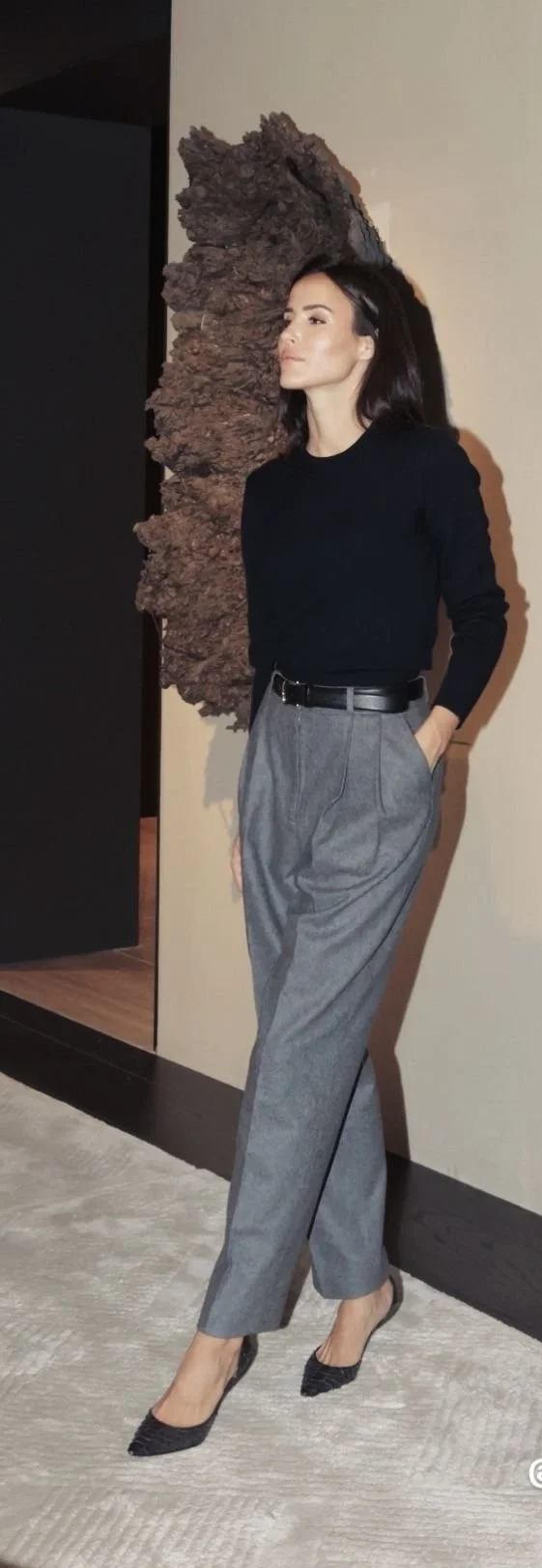 a woman wearing wool top and grey trousers
