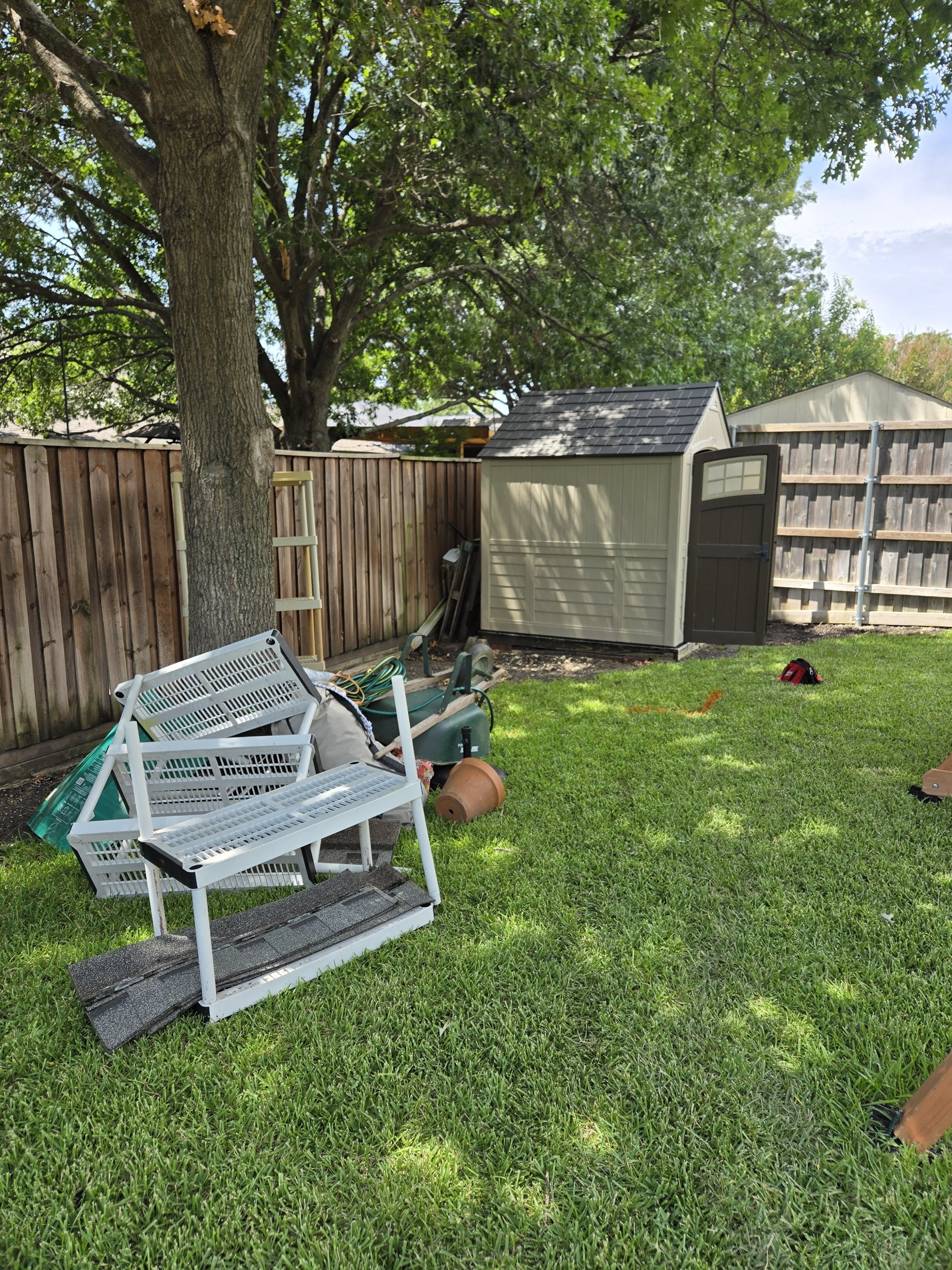 Backyard before shed removal and outdoor junk cleanup in Richardson, TX with an old storage shed and unwanted items.