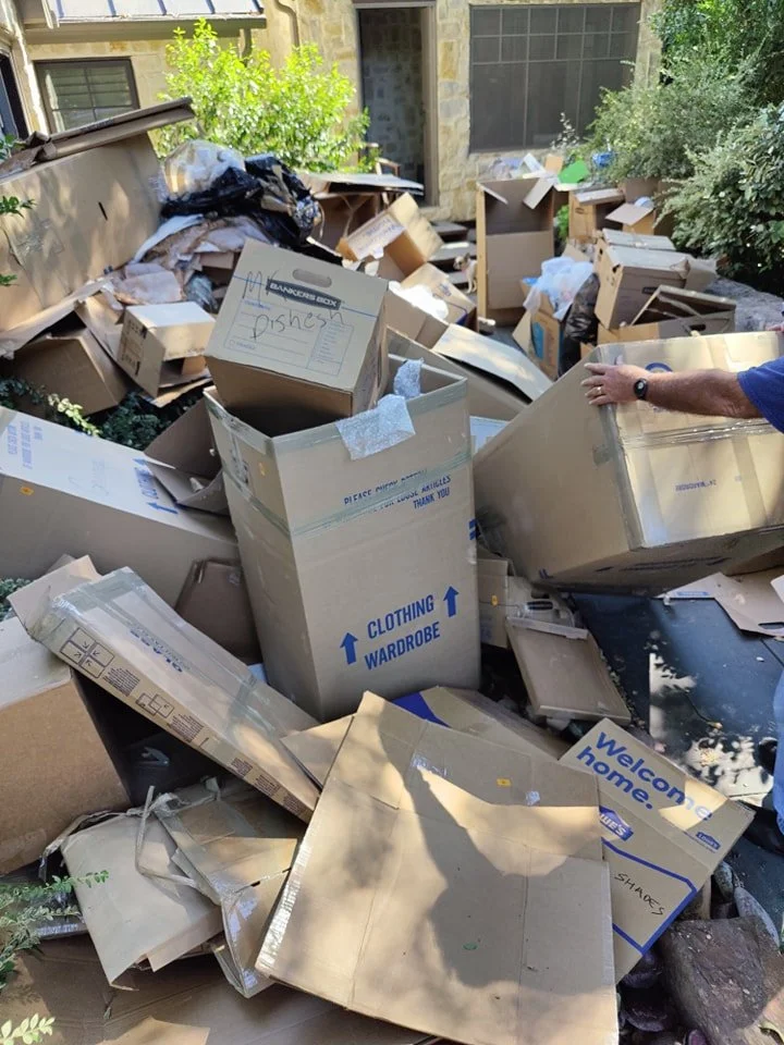Before photo of large cardboard and moving box pile outside a home in the Chase Oaks area of Plano, TX before junk removal.
