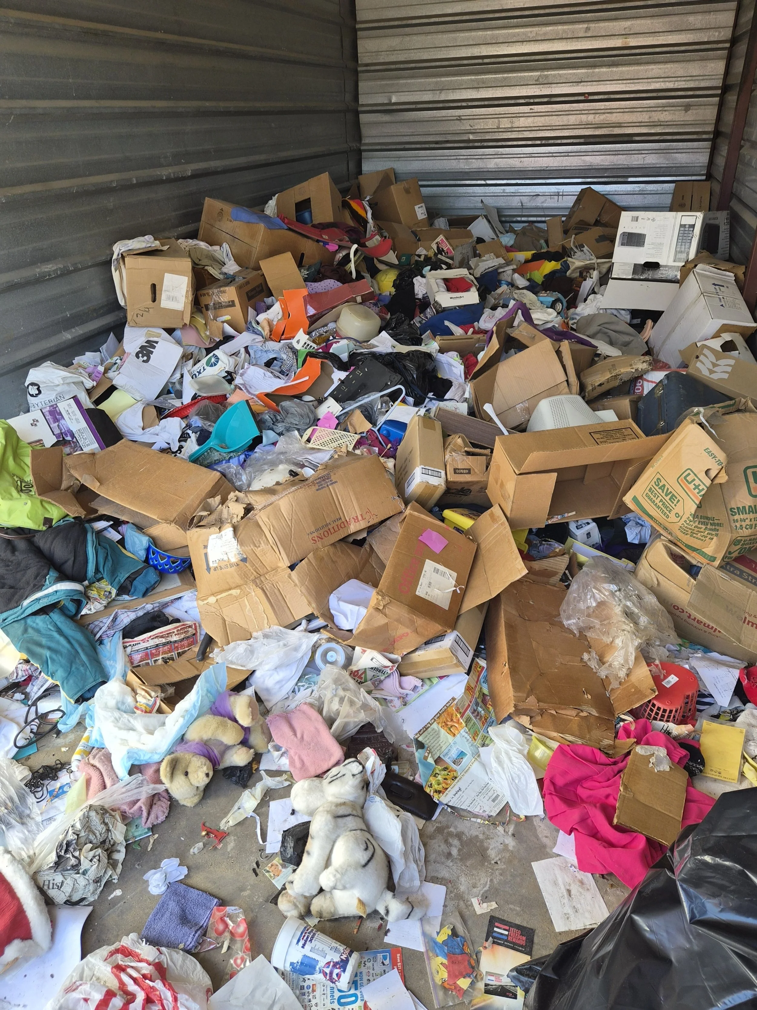 Storage unit cleanout before photo – cluttered unit full of boxes and trash in Plano TX