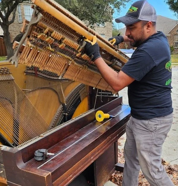Quick Junk Removal professional breaking down a piano for efficient removal in Plano, TX, and CQuick Junk Removal hauling away an old piano in Plano TXollin County.