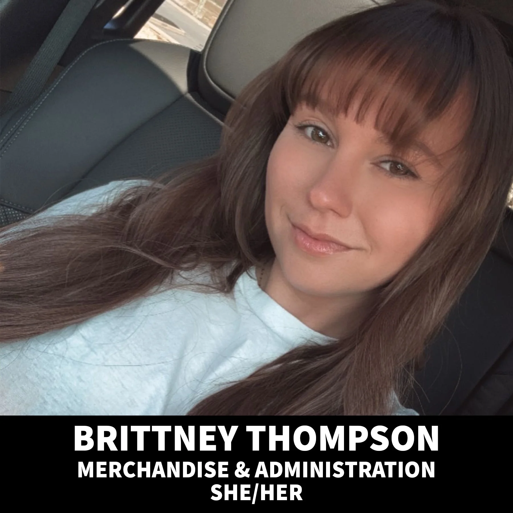Portrait of a smiling woman with long wavy blonde hair, wearing a black top and layered gold necklaces, against a black background.