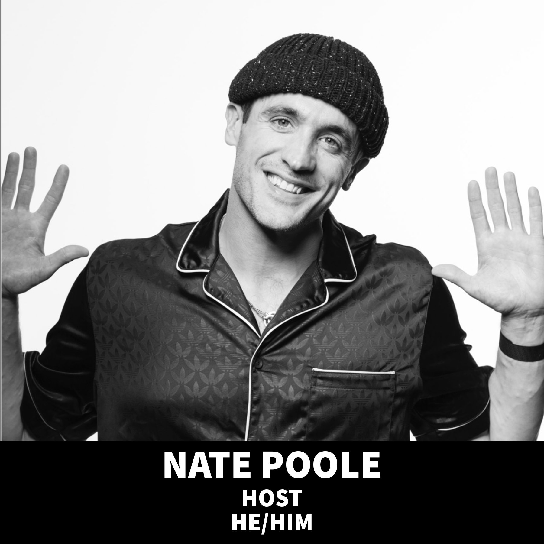 A smiling man with dark hair wearing a black knit cap and black shirt against a black background.