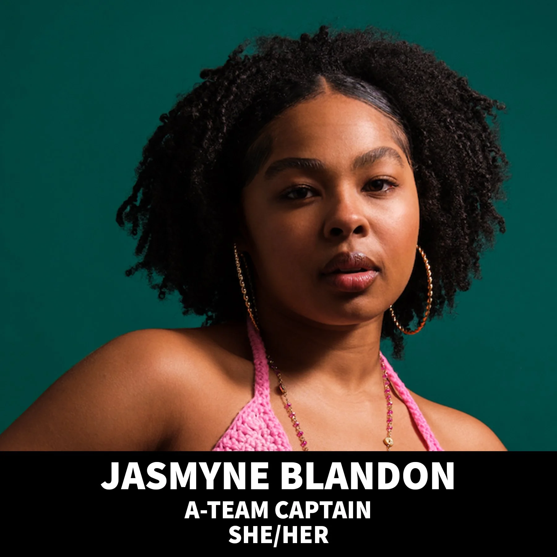 A young woman with braided hair, wearing hoop earrings and a black spaghetti strap top, smiling softly against a black background.