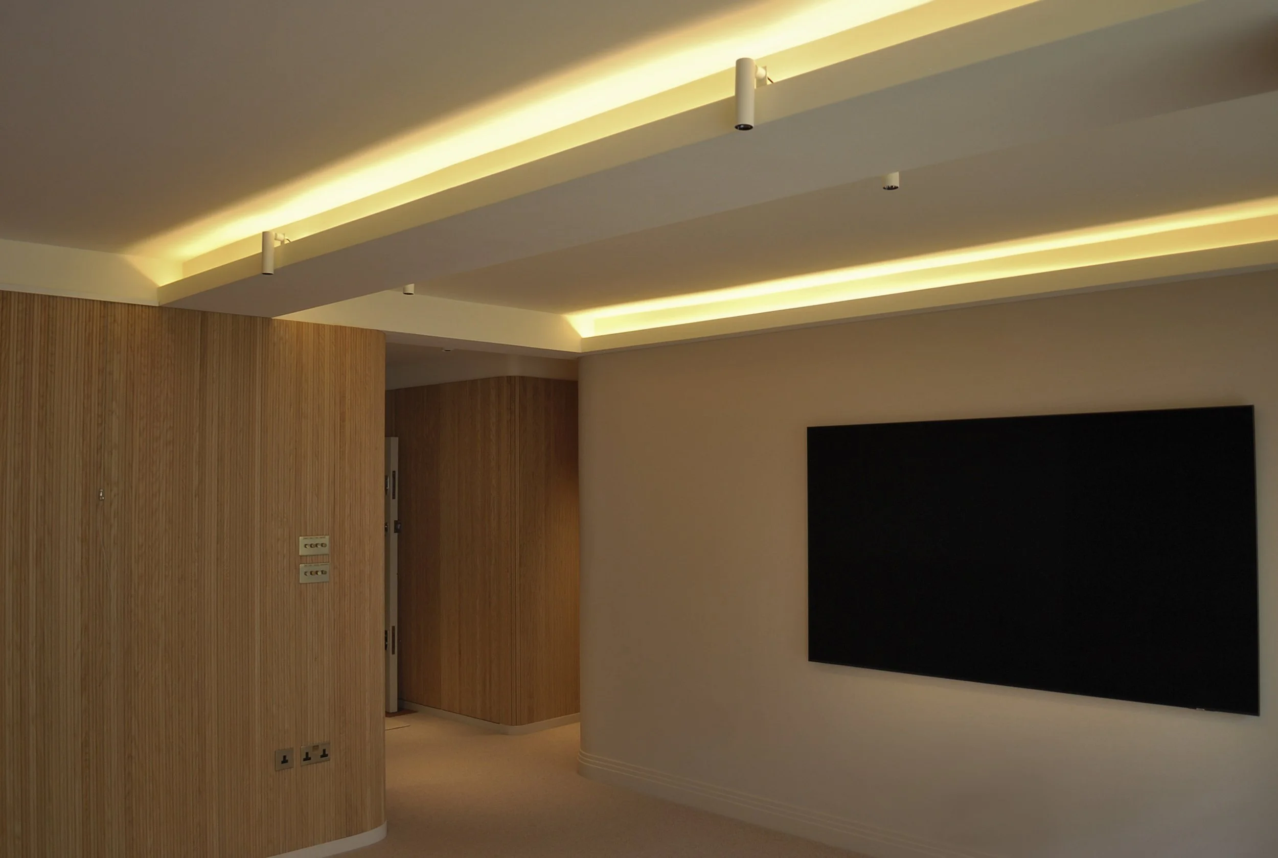 Chelsea flat refurbishment with integrated lighting and curved timber wall finishes