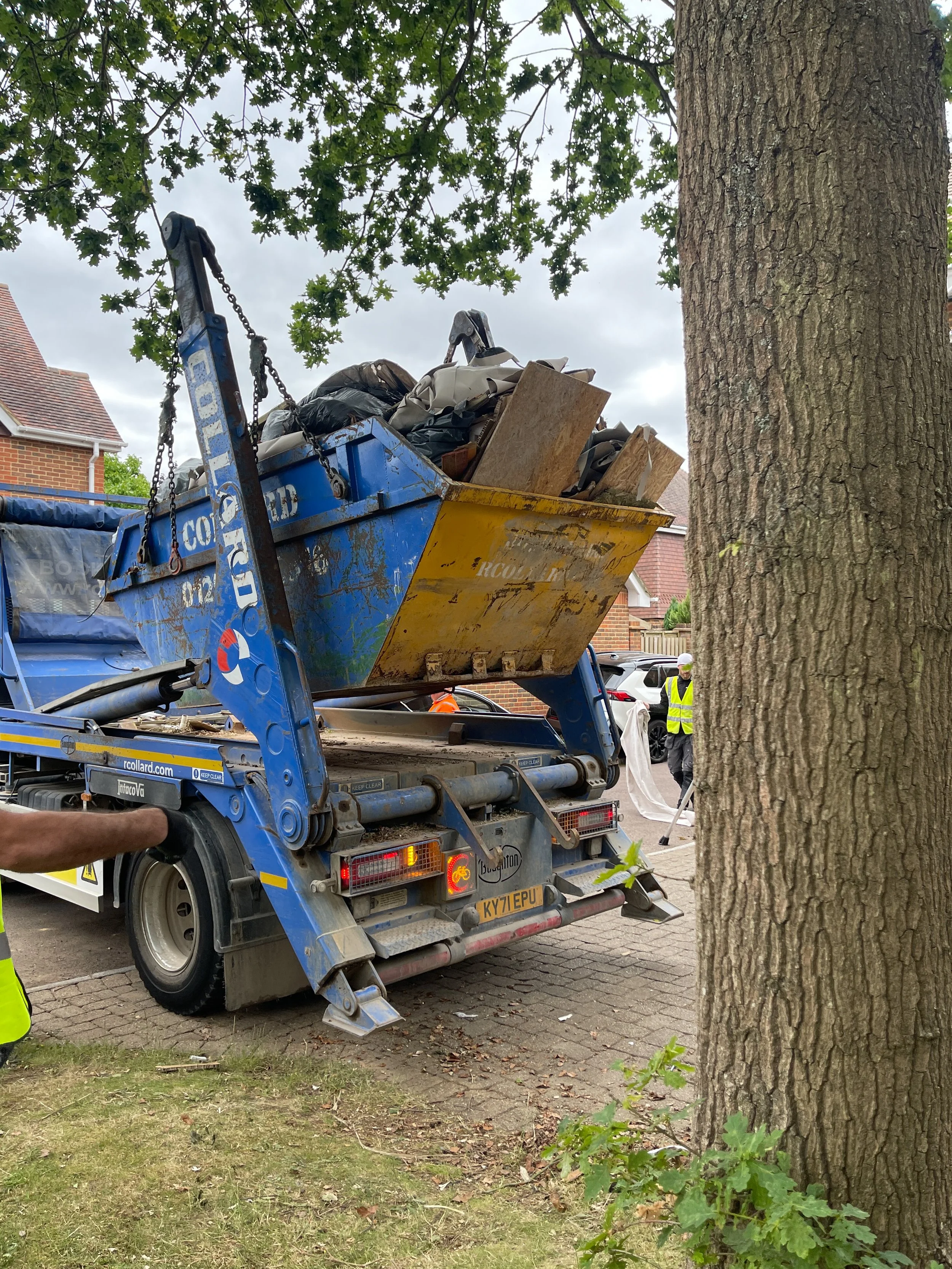Skip lorry collecting renovation waste during home refurbishment project in London
