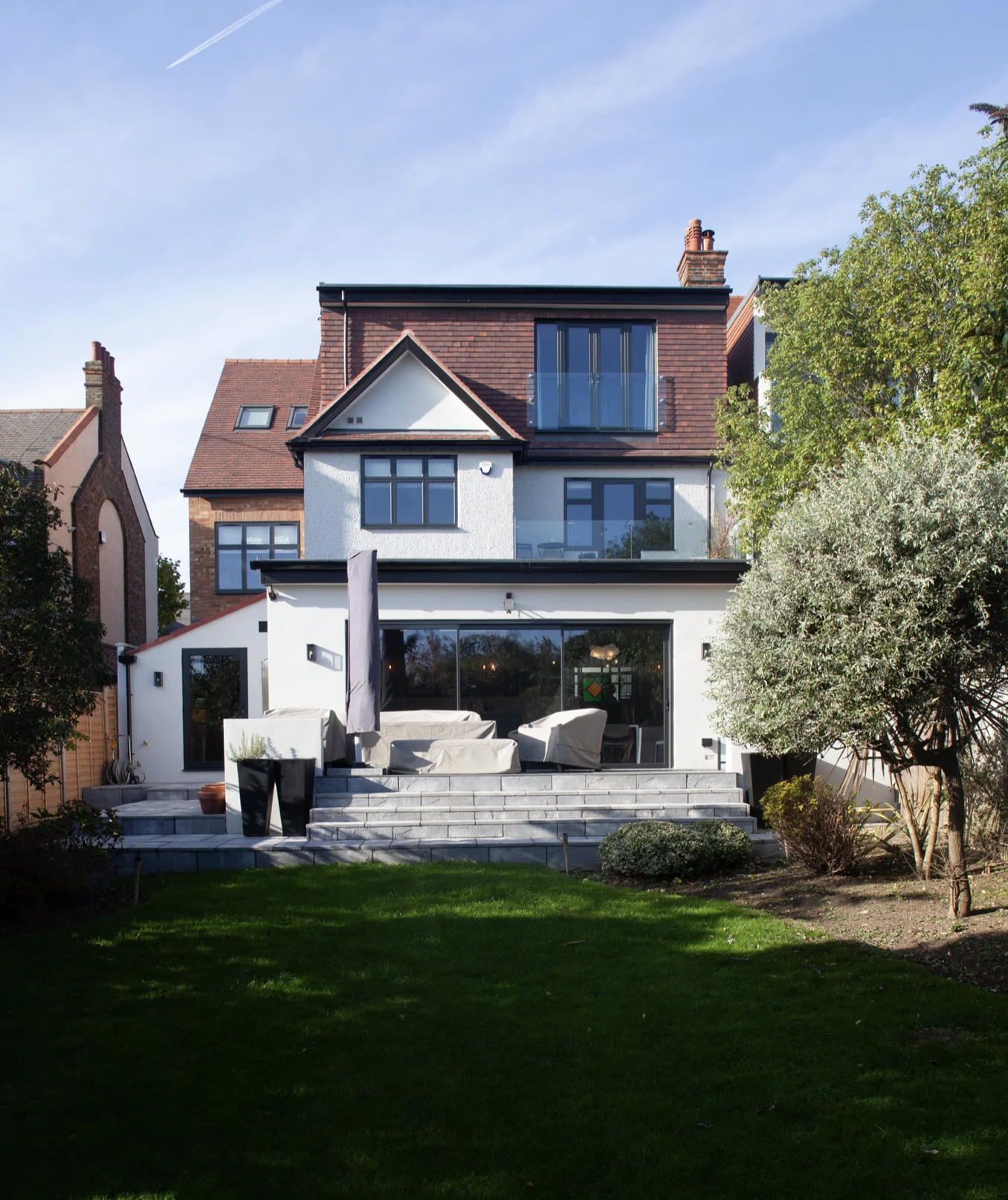 Completed rear extension and loft conversion in London with garden landscaping.