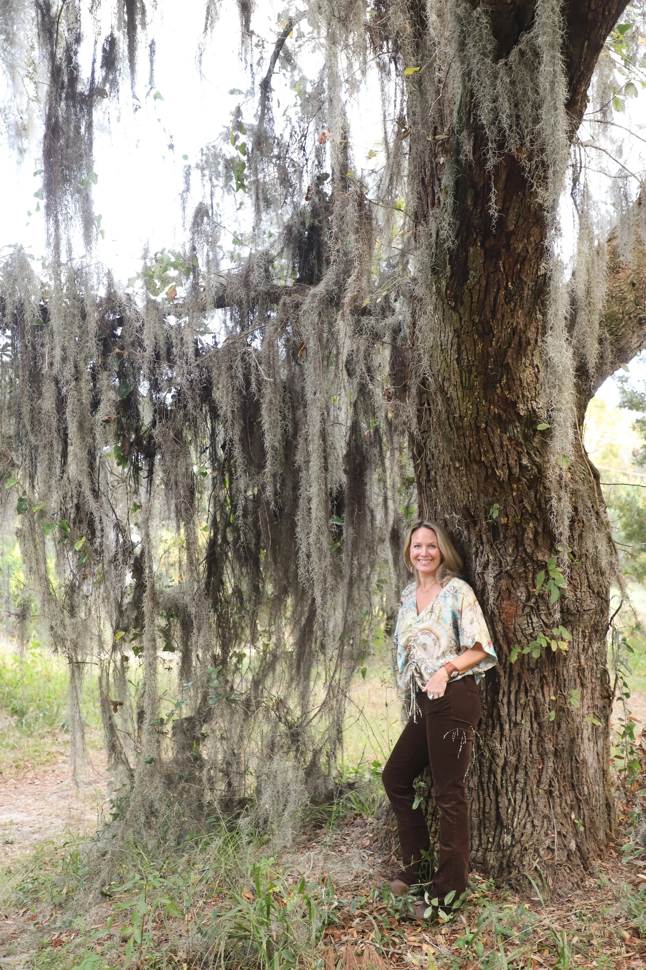 emily standing next to tree